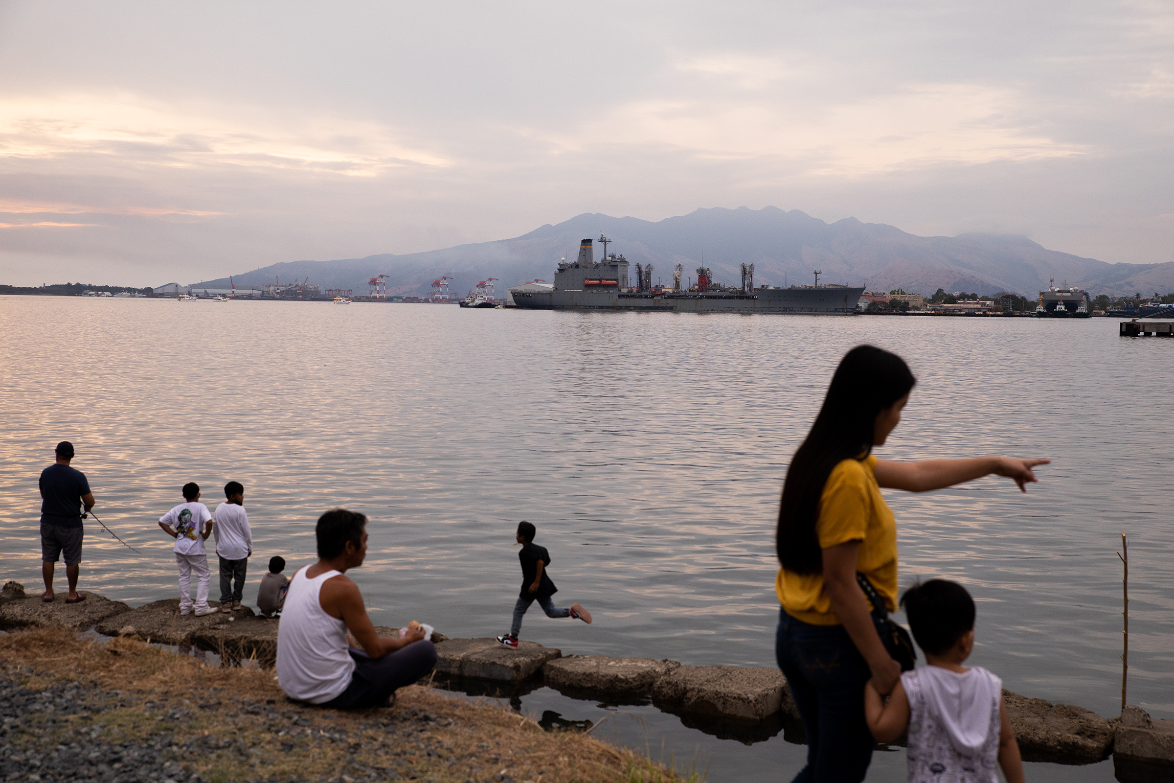 People enjoy the sunset by Malawaan Picnic Park at the Subic Bay Freeport Zone in the province of Zambales, Philippines, on Feb. 20, 2023. (Geric Cruz for TIME)