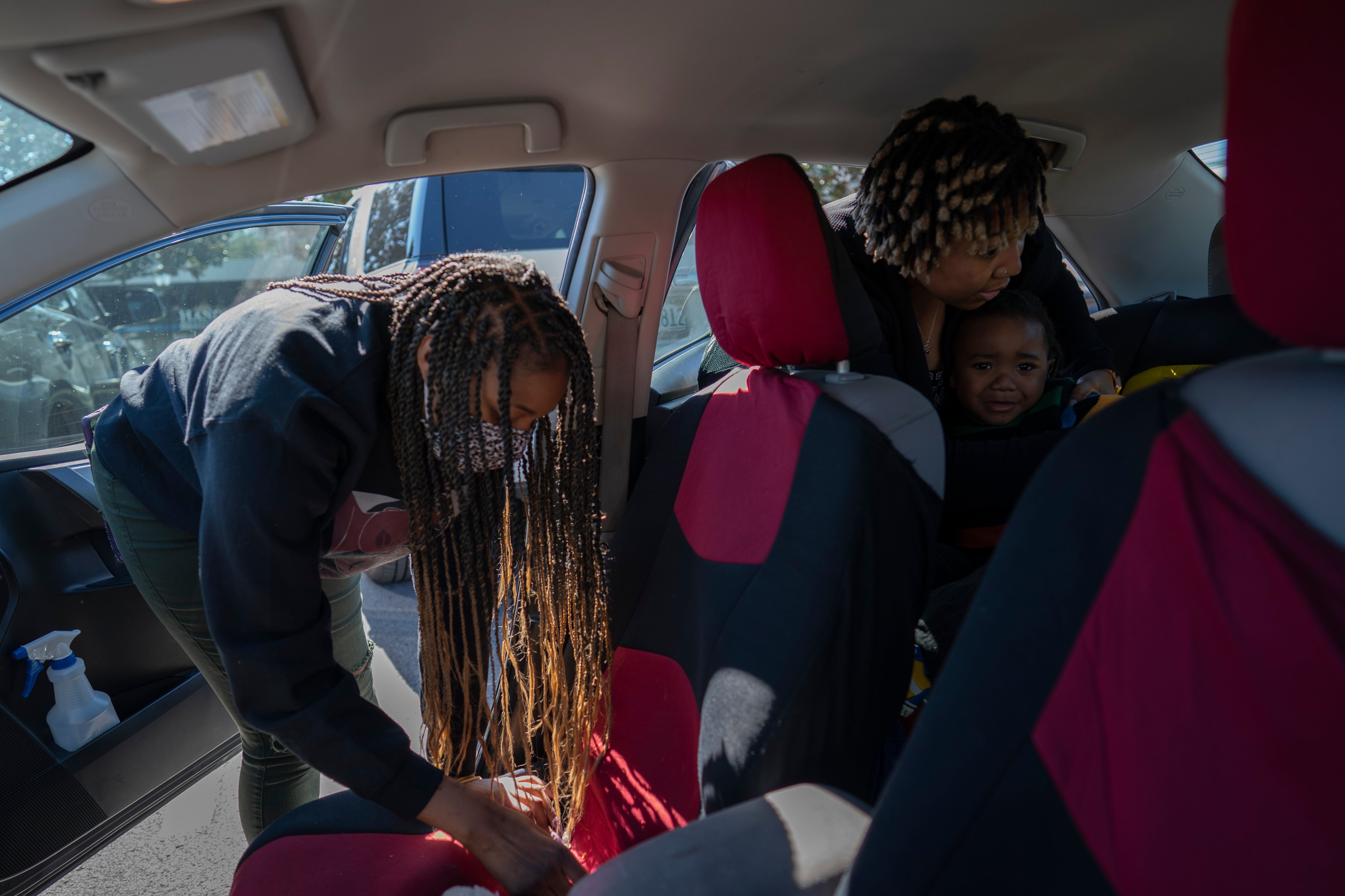 Angelica Lyons secures her 2-year old son Malik into his child car seat while her sister, Ansonia Lyons, prepares to ride with her after their breakfast outing to celebrate their father's birthday, (Wong Maye-E—AP Photo)