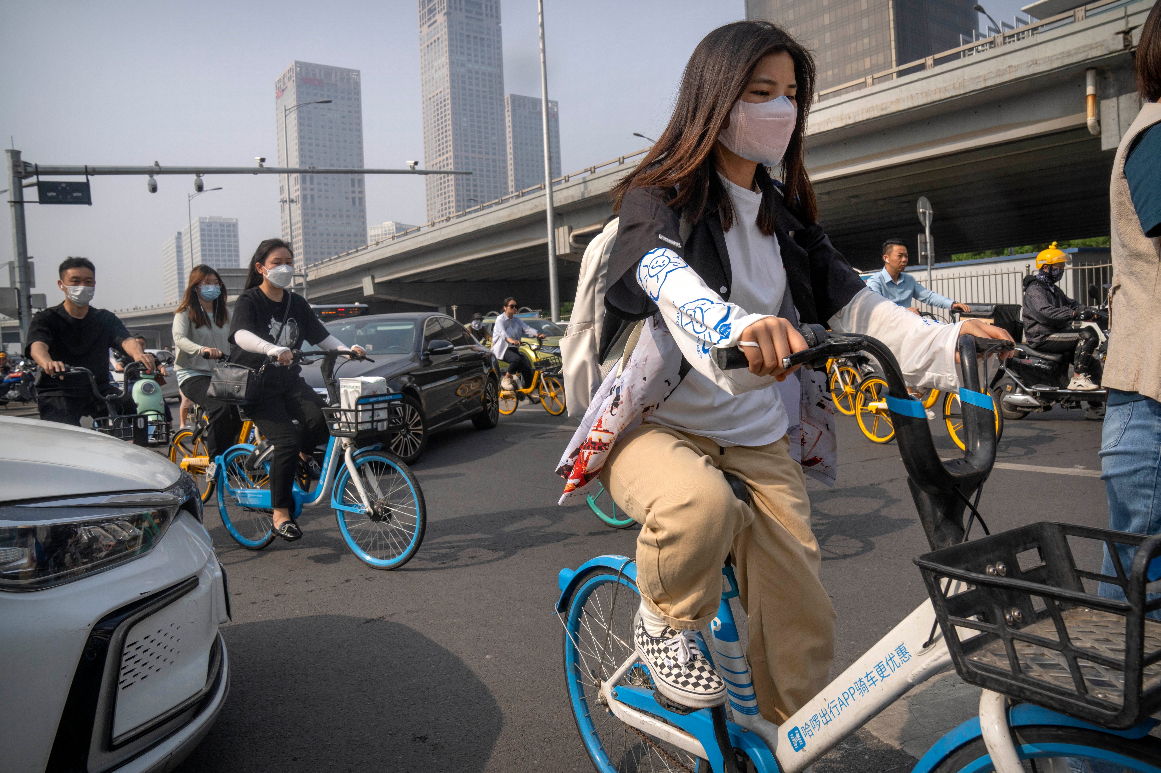 Commuters wearing face masks make their way along a street in the central business district during the morning rush hour in Beijing. (Mark Schiefelbein—AP Photo)