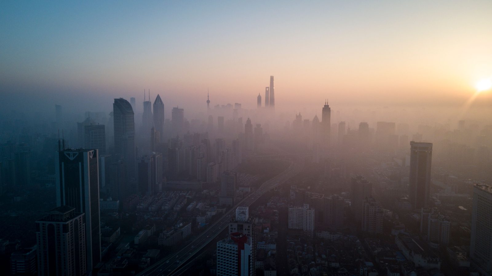 The sun rising above the skyline of a highly polluted Shanghai.