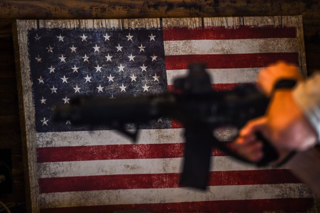 An instructor teaches handling of AR-15 rifles with a U.S. flag in the background during a shooting course at Boondocks Firearms Academy in Jackson, Mississippi on September 26, 2020. (Chandan Khanna—AFP/Getty Images)