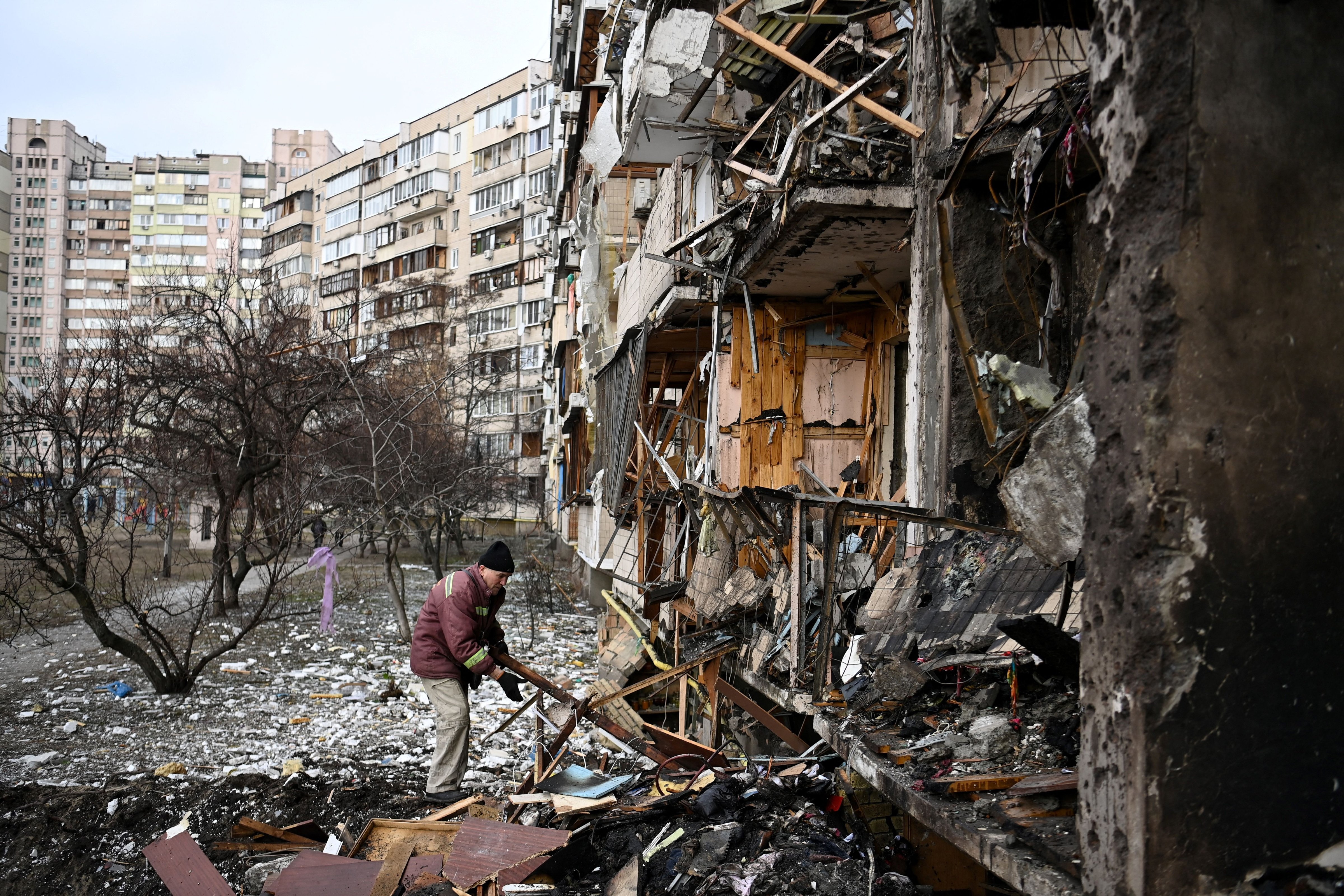 A man clears debris at a damaged residential building at a suburb of the Ukrainian capital Kyiv. (Daniel Leal—AFP/Getty Images)