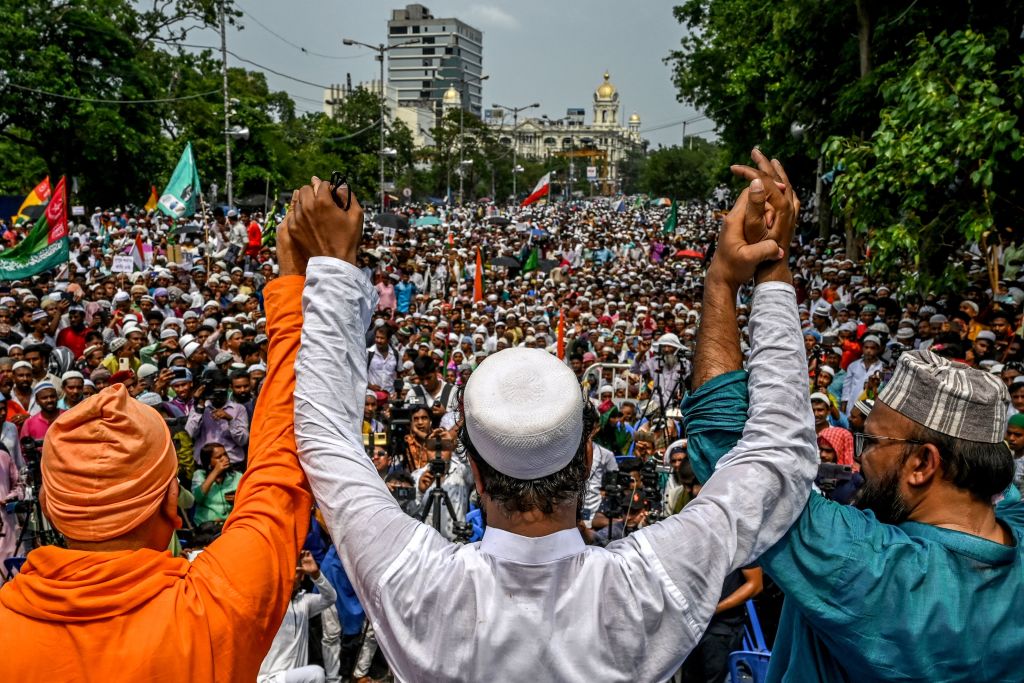 Muslim activists along with a member from Hindu organization Ramakrishna Mission, left, take part in a unity rally to promote communal harmony in Kolkata on June 14, 2022. (Dibyangshu Sarkar—AFP/Getty Images)