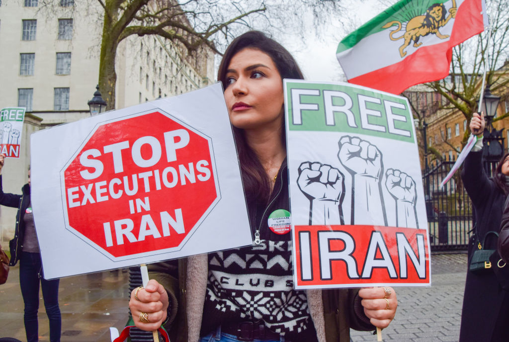A protester holds 'Stop executions in Iran' and 'Free Iran' placards during a demonstration outside Downing Street in London on Jan. 14, 2023. (Vuk Valcic—SOPA Images/LightRocket via Getty Images)