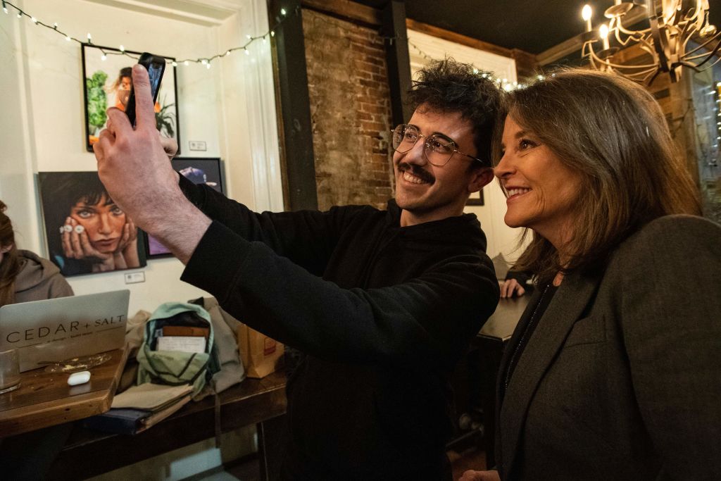 US presidential hopeful Marianne Williamson (R) takes a photograph with an attendee as she campaigns at a coffee shop in Portsmouth, New Hampshire, on March 9, 2023 (Joseph Prezioso—AFP via Getty Images)