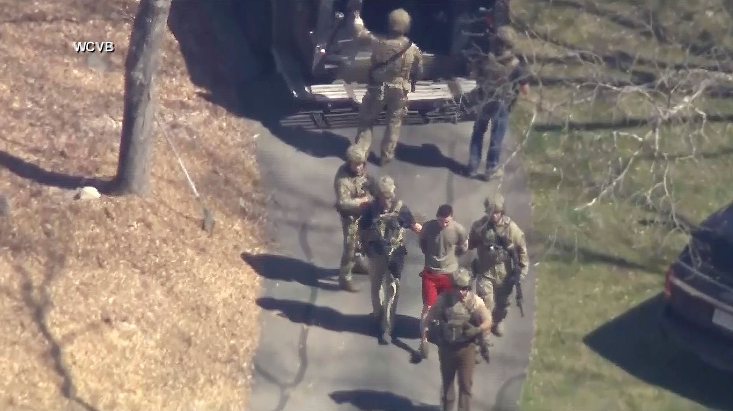 This image made from video provided by WCVB-TV, shows Jack Teixeira, in T-shirt and shorts, being taken into custody by armed tactical agents in Dighton, Mass. on April 13, 2023.