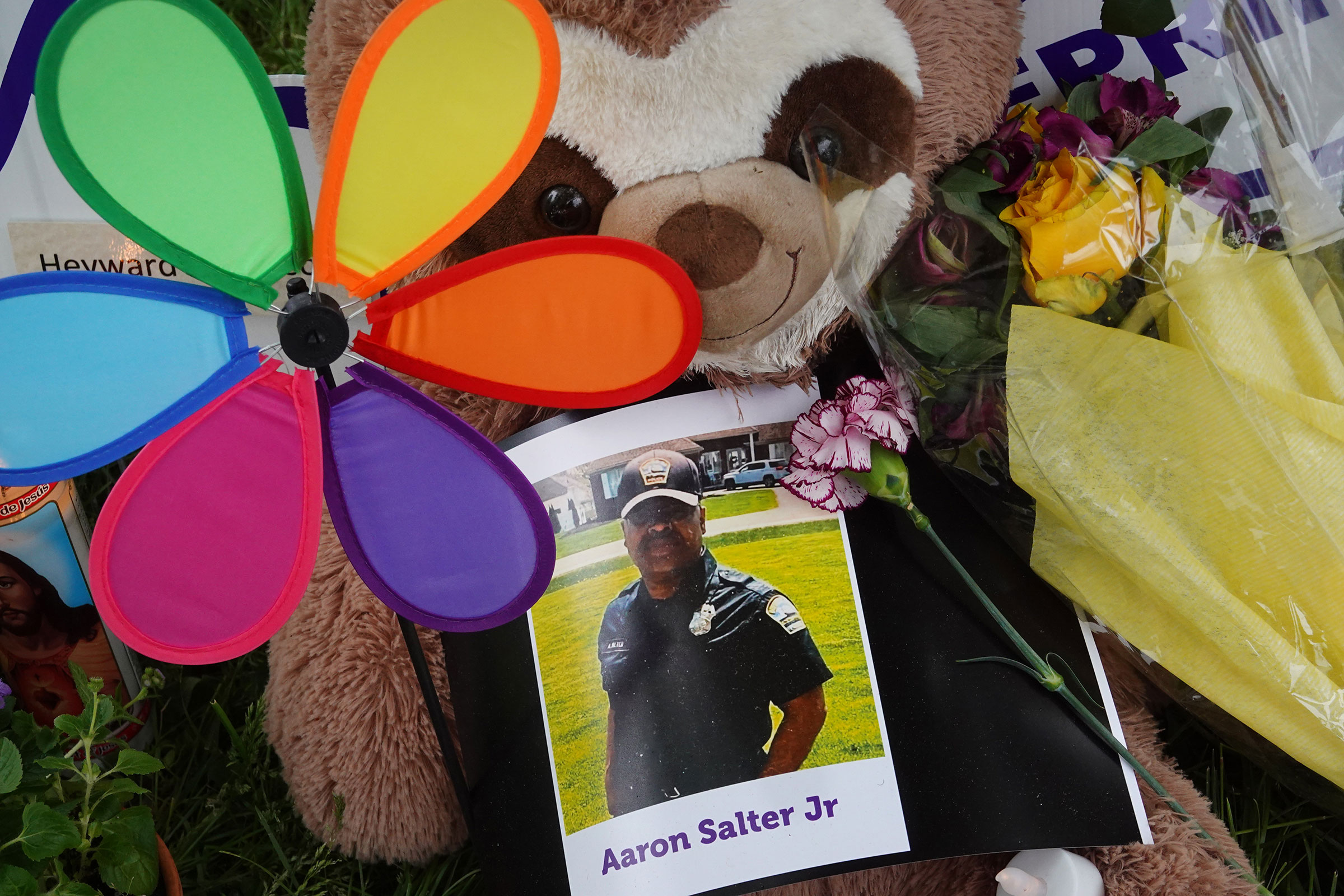 Flowers, candles and mementoes are left in honor of Aaron Salter Jr., the security guard who was shot and killed trying to stop a gunman at the Tops supermarket, at a makeshift memorial outside the store in Buffalo on May 18, 2022.