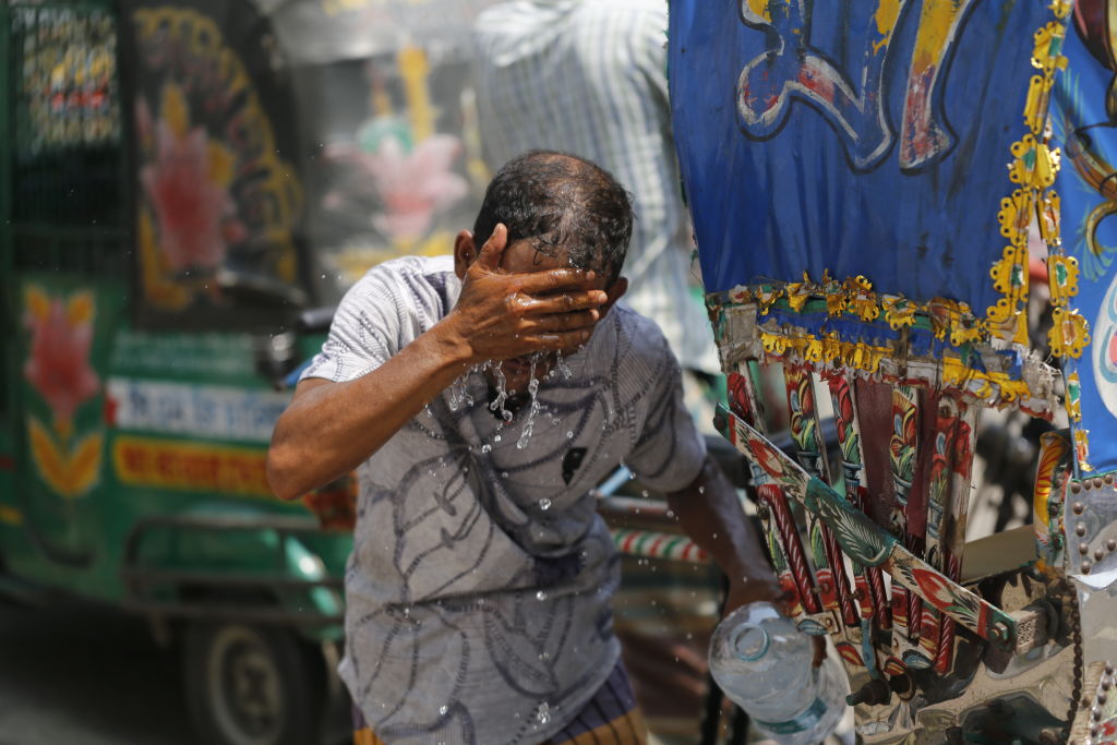 A Rickshaw puller splashes water on his face to get relief during a heatwave in Dhaka, Bangladesh on May 10, 2023. (ehman Asad/NurPhoto—Getty Images)