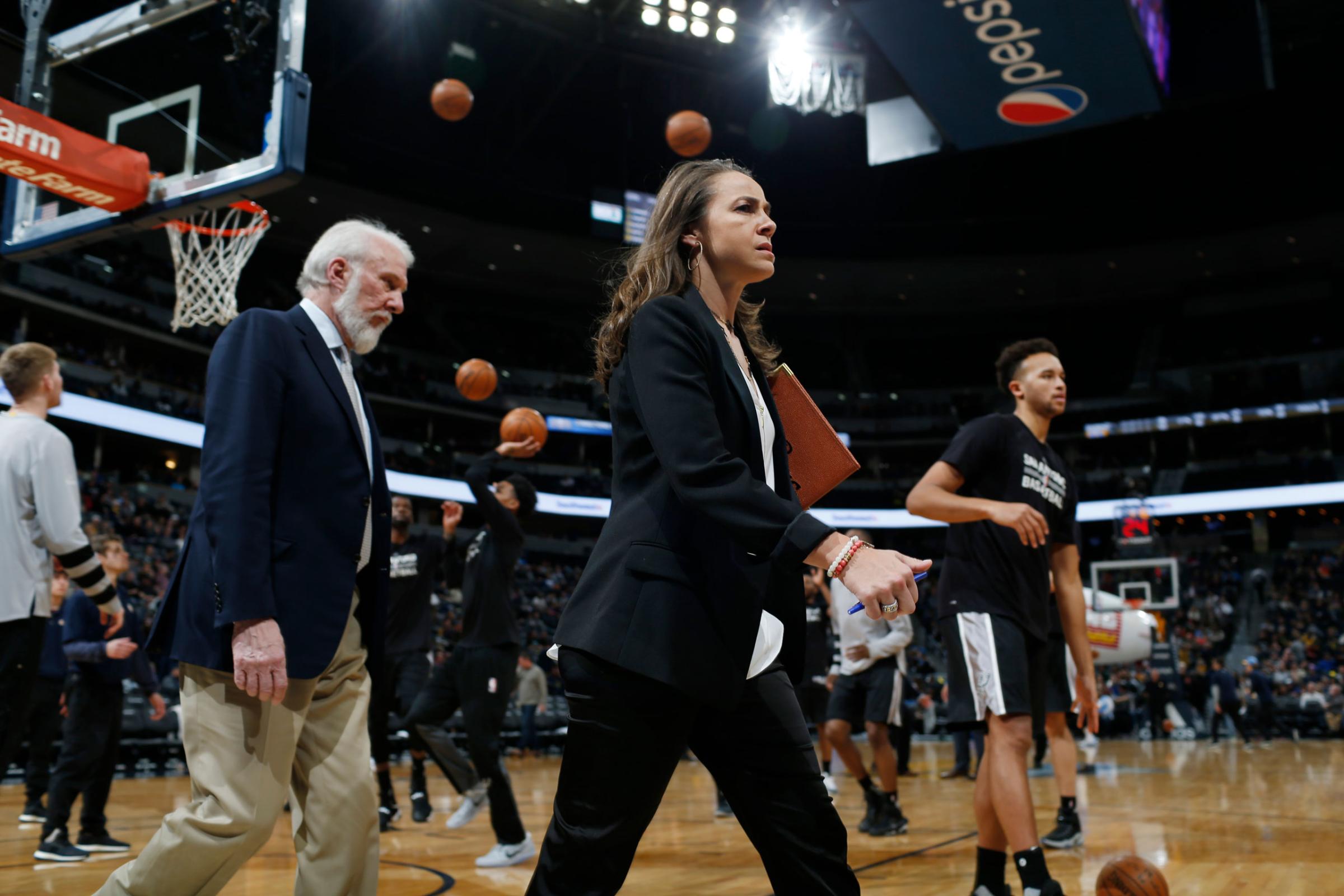 Assistant coach Becky Hammon and head coach Gregg Popovich in the court during a San Antonio Spurs game in 2017.