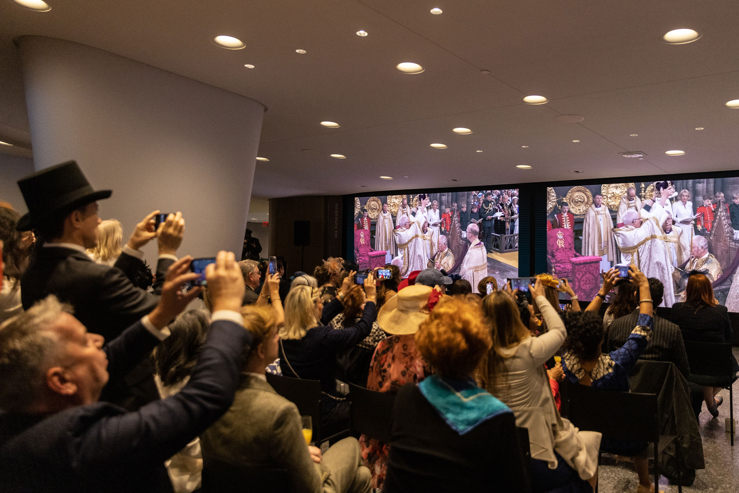 İnsanlar, New York City'deki Lincoln Center'daki taç giyme töreni partisi sırasında Kral III. Charles'ın taç giyme töreninin televizyon gösterimini izliyor.  (Jeenah Moon—Getty Images)