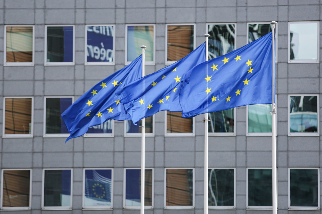The European Flag is seen in the Belgian capital in front of modern architecture buildings with glass and steel construction of the European Commission headquarters.