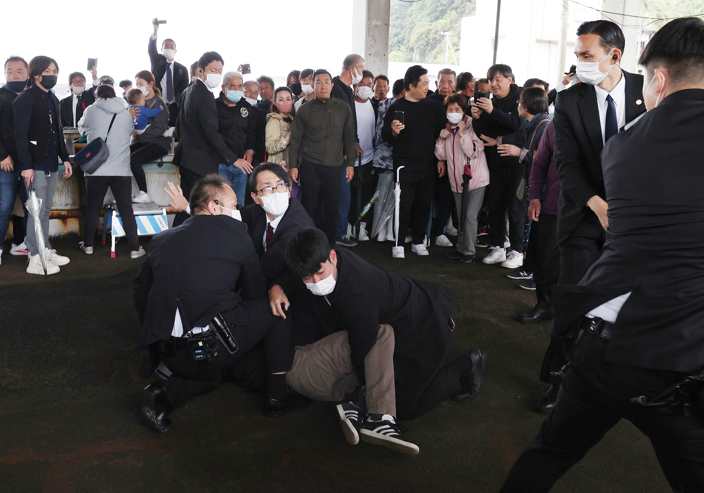 Wakayama police restrain a man who allegedly threw explosives where Kishida was scheduled to give a speech for by-election of Lower House, in Wakayama City on April 15. (The Yomiuri Shimbun/AP)