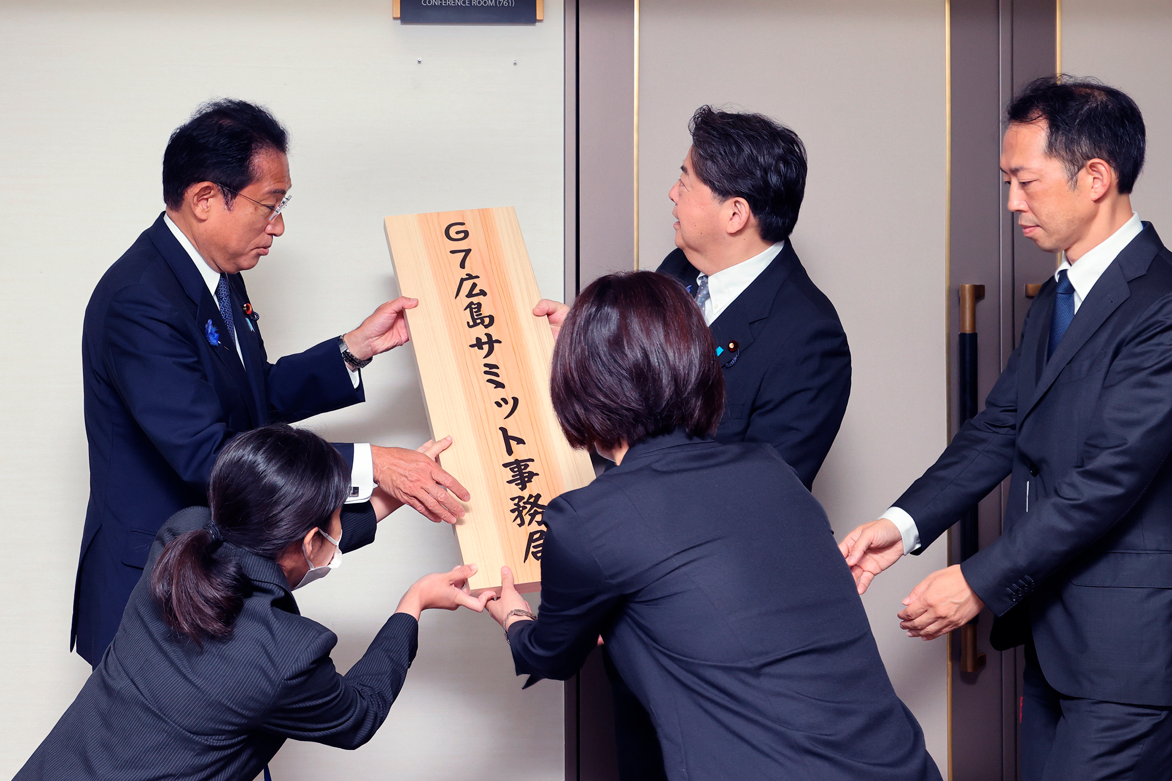 The secretariat of the G7 Summit is set up at the Foreign Ministry in Tokyo on July 15, 2022. Kishida (left), Foreign Minister Yoshimasa Hayashi (center), and Secretary General Katsuro Kitagawa hang the signboard in front of its room. (The Yomiuri Shimbun/AP)