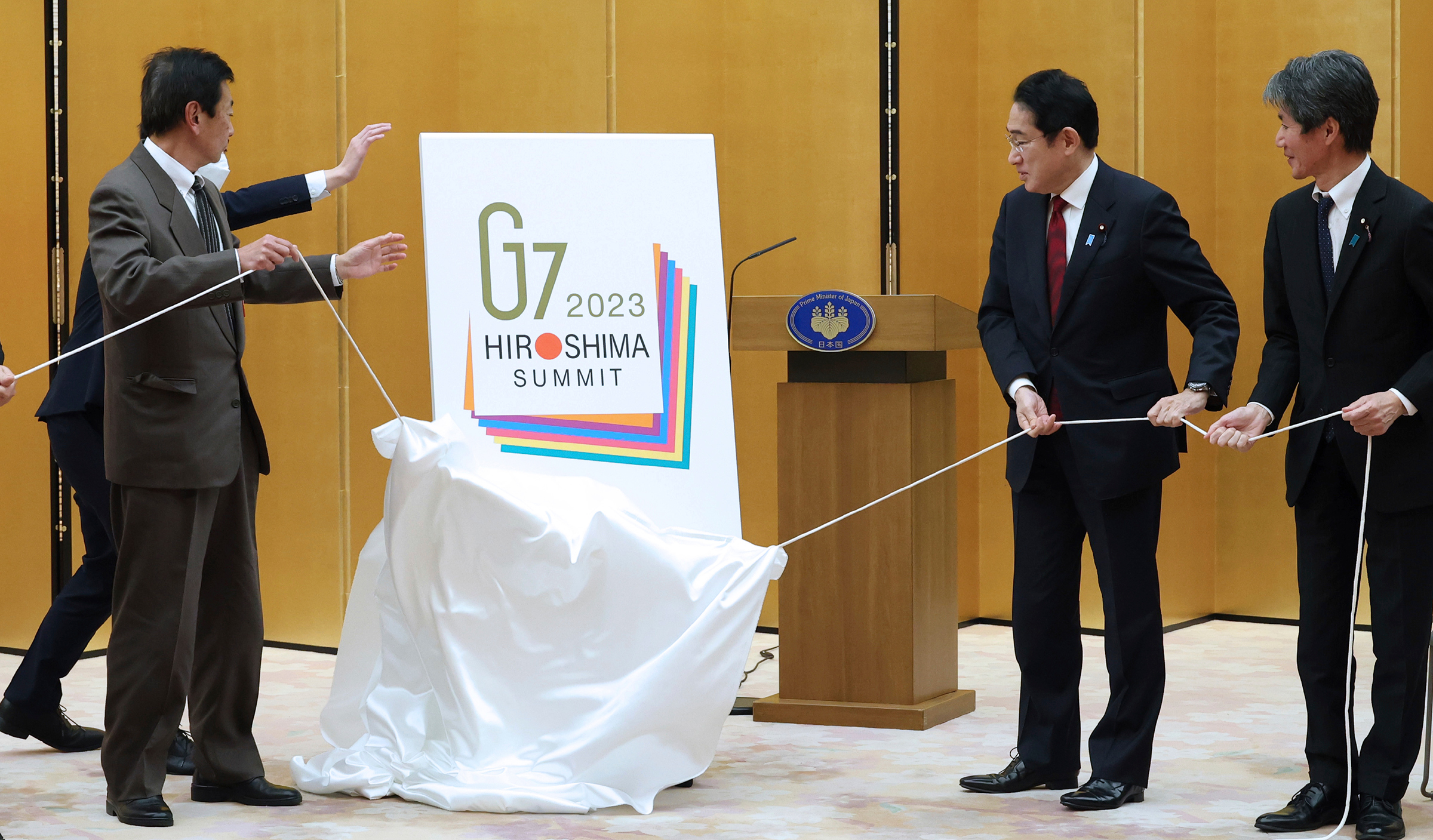 Japan Prime Minister Fumio Kishida (second from right) unveils the G7 summit logo at his Tokyo office in December. (The Yomiuri Shimbun/AP)
