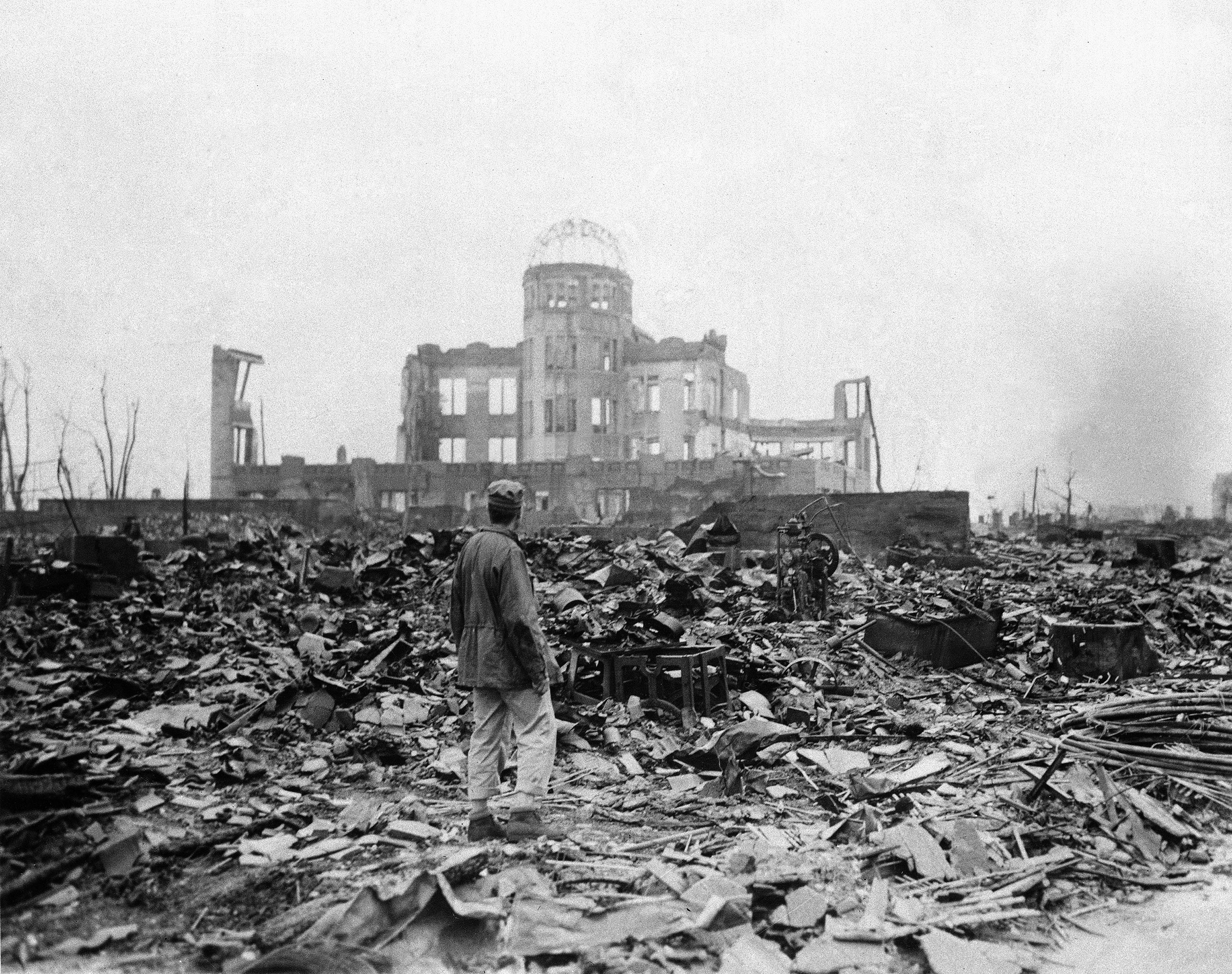 An allied correspondent stands in a sea of rubble before the shell of a building that once was a movie theater in Hiroshima, Sept. 8, 1945, a month after the first atomic bomb ever used in warfare was dropped by the U.S. to hasten Japan's surrender. (Stanley Troutman—AP)