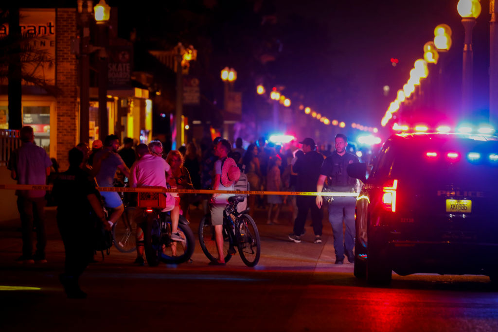 Beachgoers are seen next to law enforcement officers on a crime scene as they respond to a shooting at Hollywood Beach on May 29, 2023 in Hollywood, Florida. (Eva Marie Uzcategui—Getty Images)