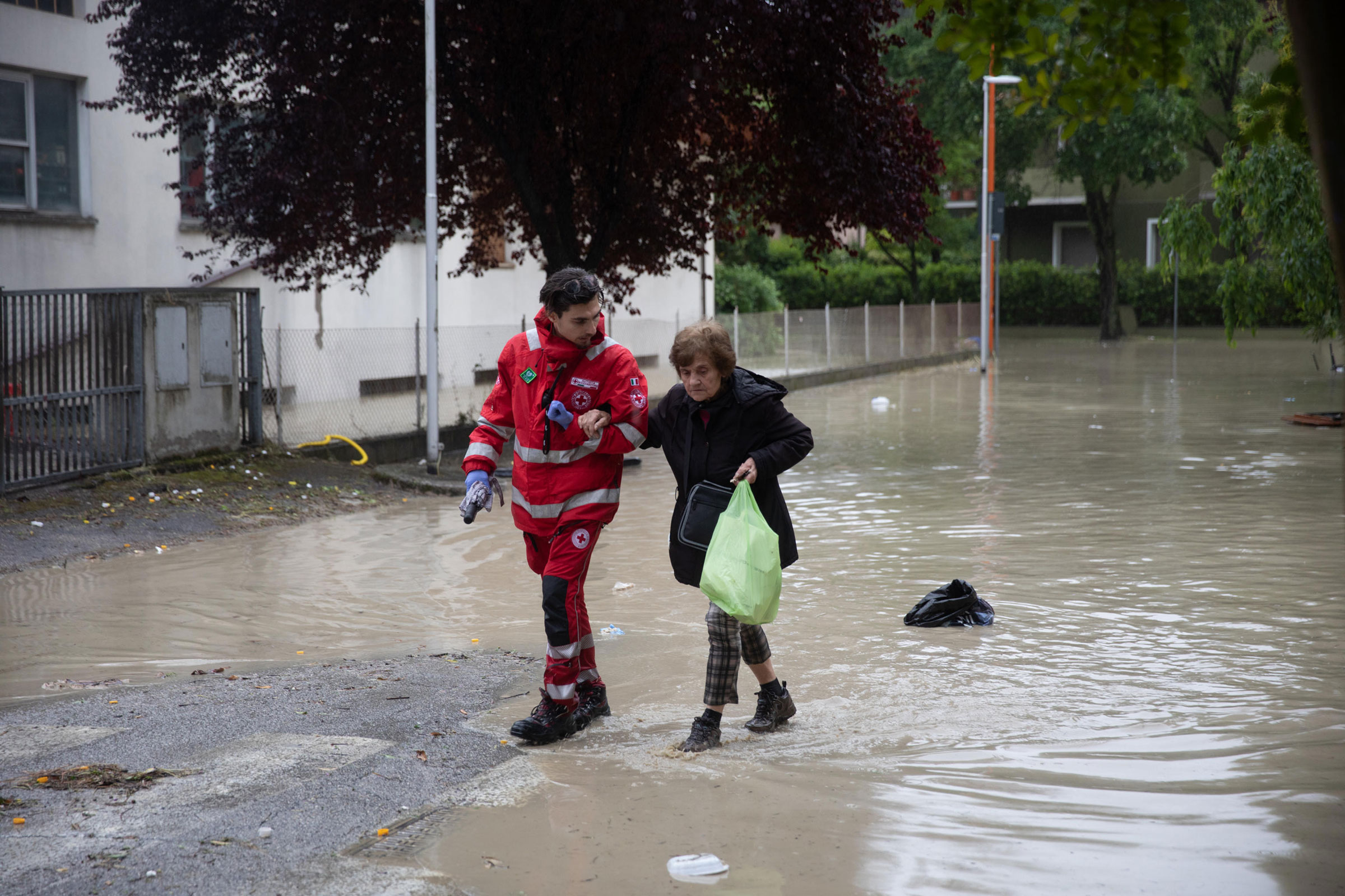 A member of the Italian Red Cross helps a resident evacuate after the flooding of the Savio river, in Cesena, on May 16.