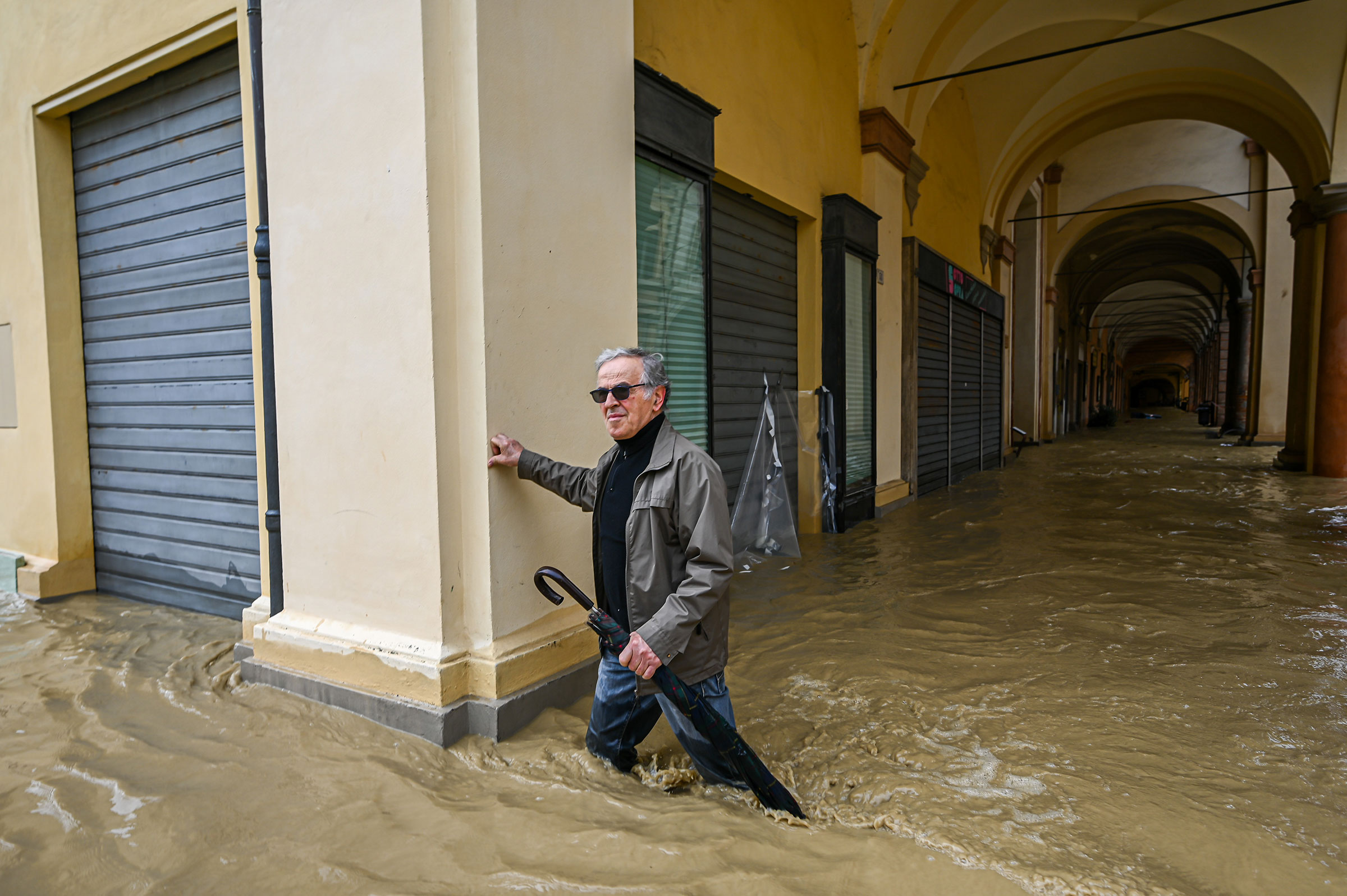 A pedestrian walks in a flooded street in Castel Bolognese, near Imola, on May 17. (Piero Cruciatti—Anadolu Agency/Getty Images)