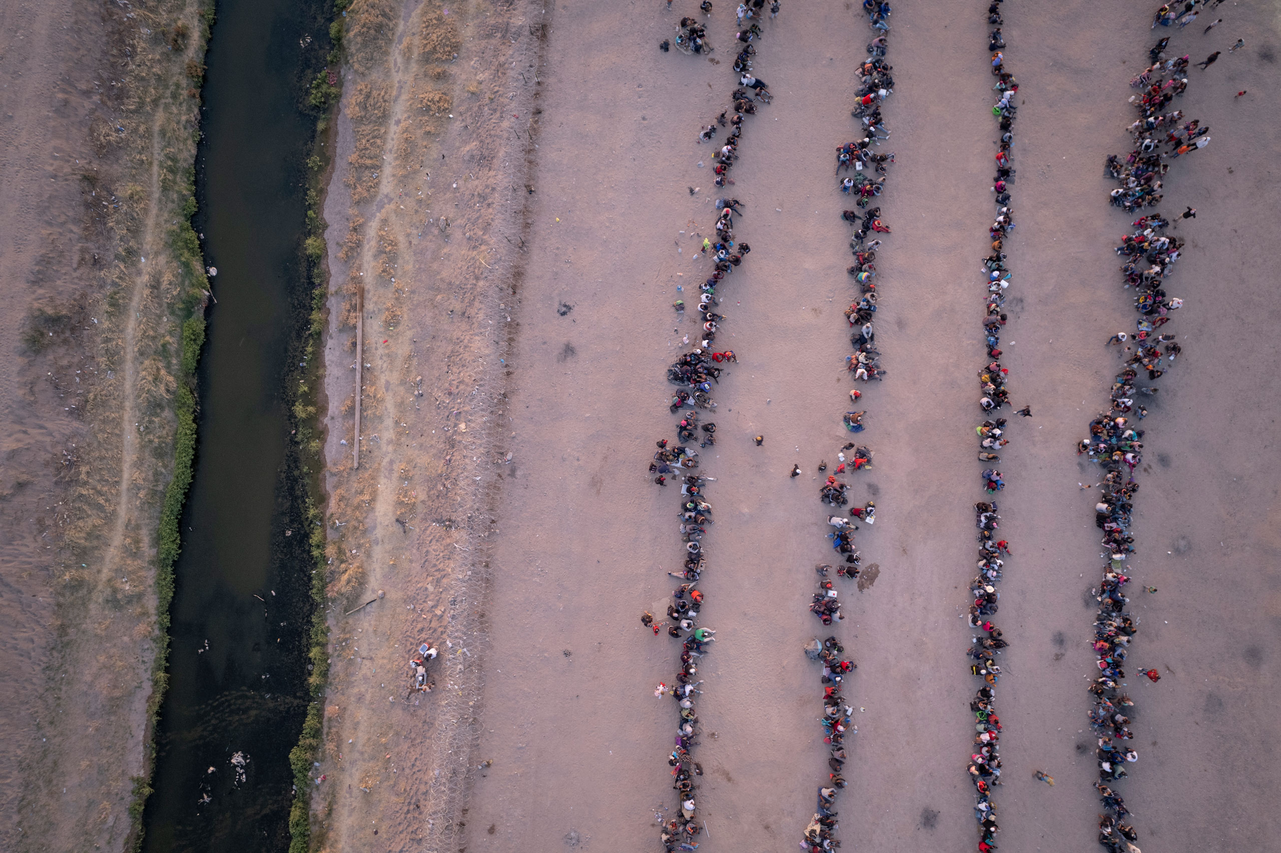 As seen from an aerial view, immigrants wait to be processed to make asylum claims after crossing the Rio Grande from Mexico into El Paso, Texas, on May 9, 2023. (John Moore—Getty Images)