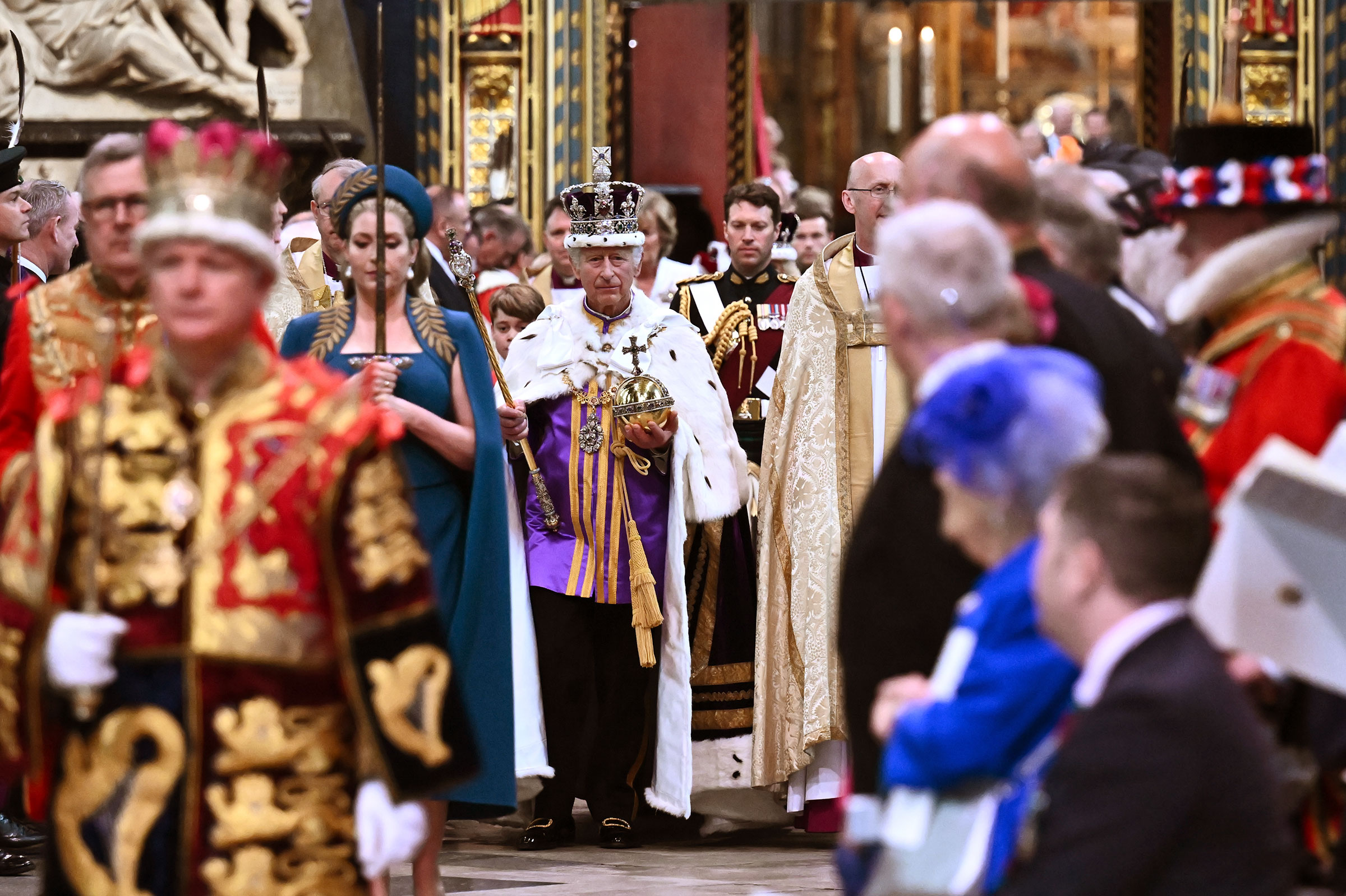 King Charles III wearing the Imperial state Crown carrying the Sovereign's Orb and Sceptre leaves Westminster Abbey after the Coronation ceremony. (2023 Getty Images)