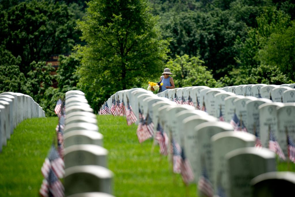 A woman carries flowers through Arlington Cemetery in Arlington, Virginia, on May 29, 2022. (Stefani Reynolds/AFP—Getty Images)