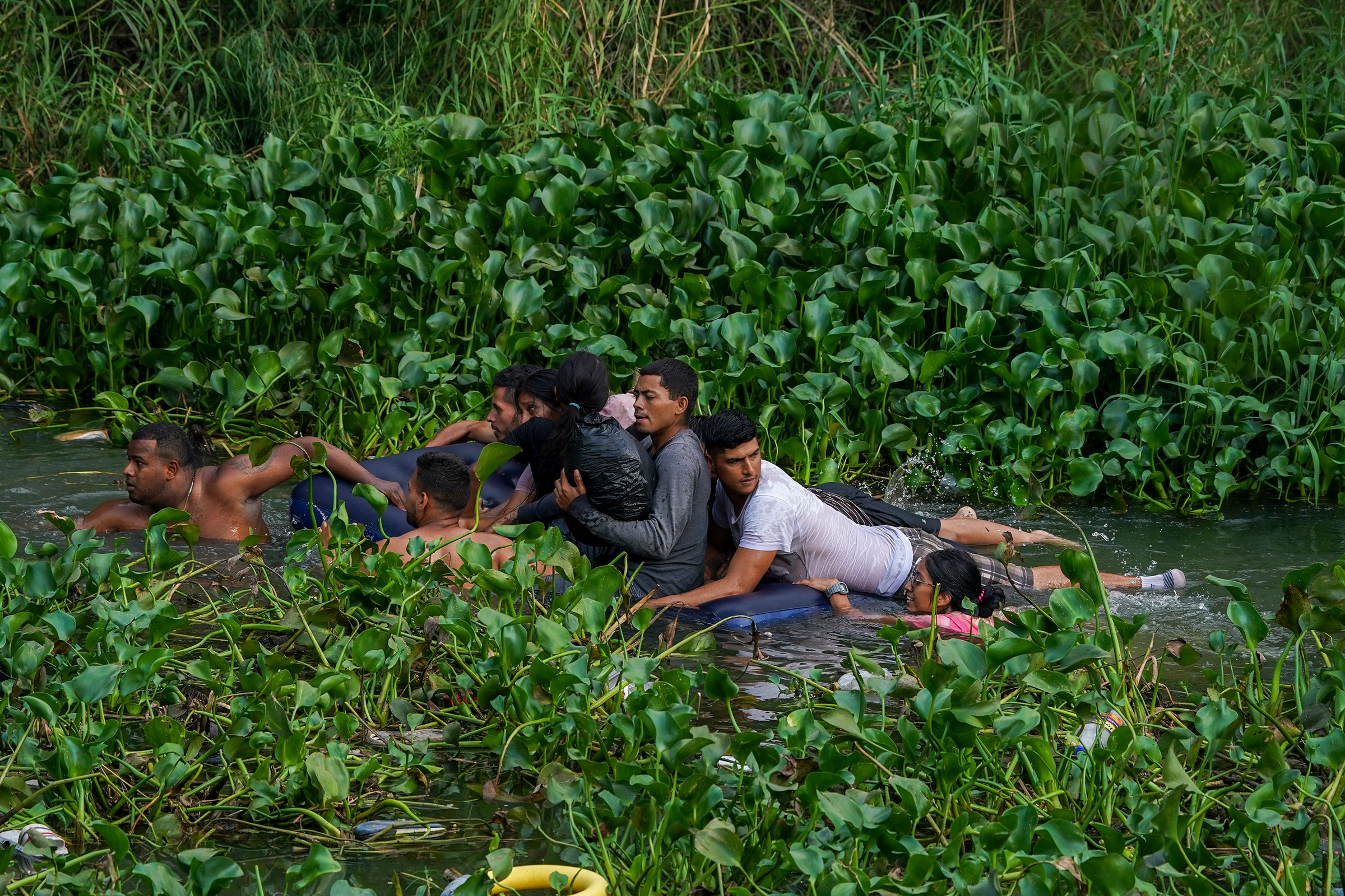 Migrants cross the Rio Bravo on an inflatable mattress into the United States from Matamoros, Mexico, on May 9, 2023. (Fernando Llano—AP)