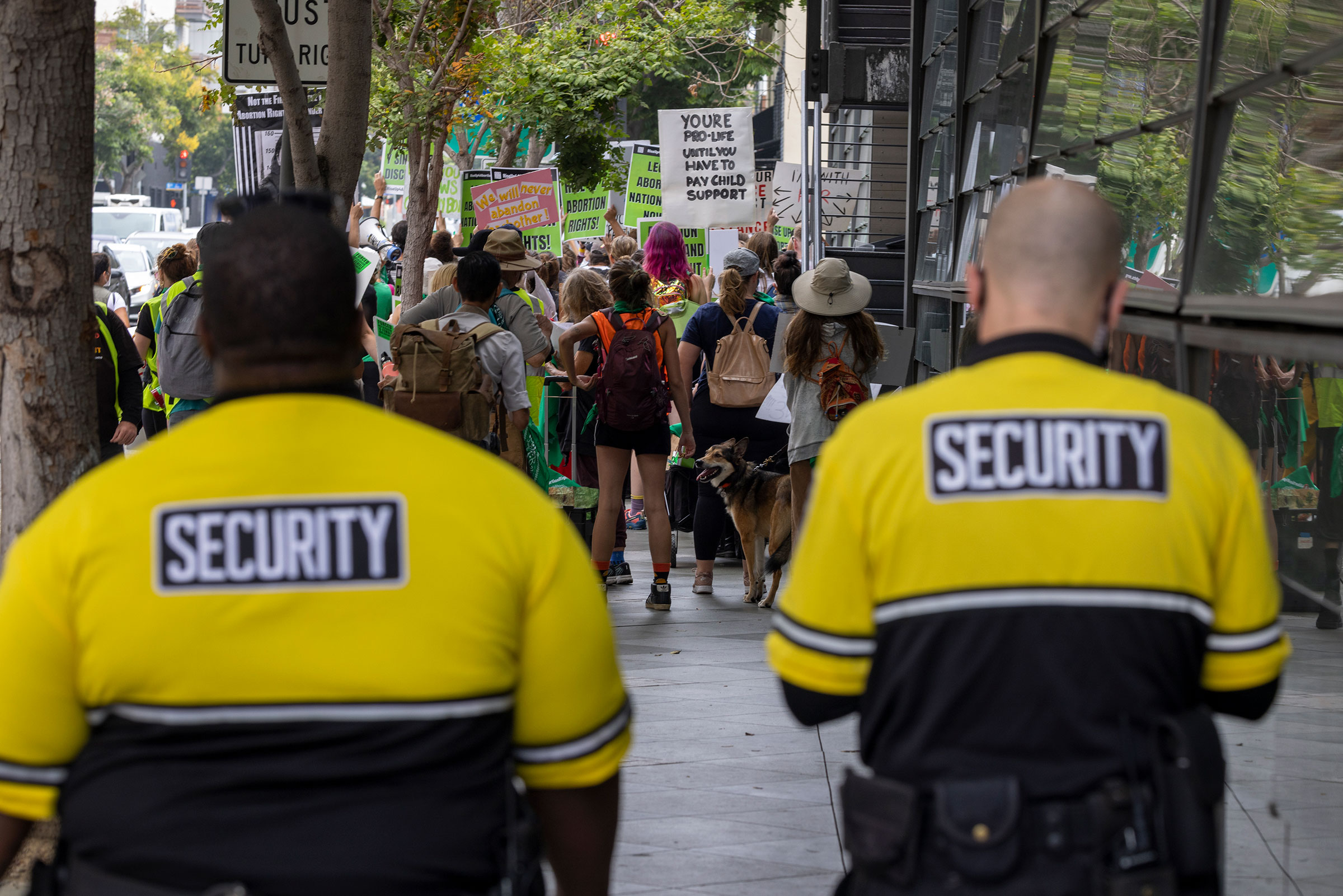 Private security guards follow behind protesters marching to a Planned Parenthood office, which was targeted by Proud Boys and an anti-abortion group the previous week, to denounce the US Supreme Court decision to end abortion rights protections in Santa Monica, Calif. on July 16, 2022.