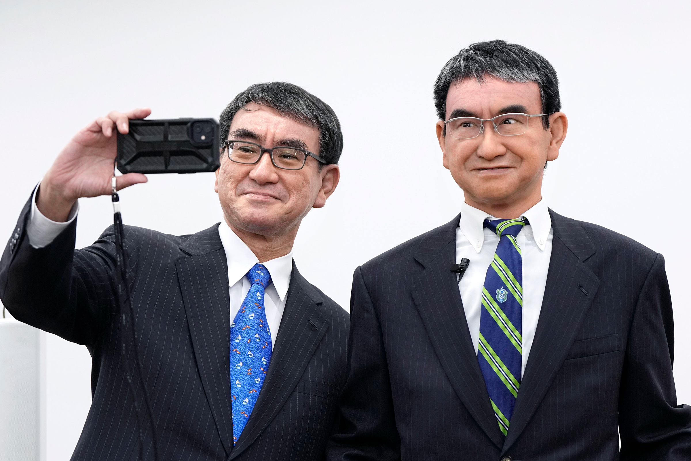 Japanese Digital Minister Taro Kono takes a selfie with his avatar robot in Tokyo on Oct. 21, 2022. (Kyodo News/AP)