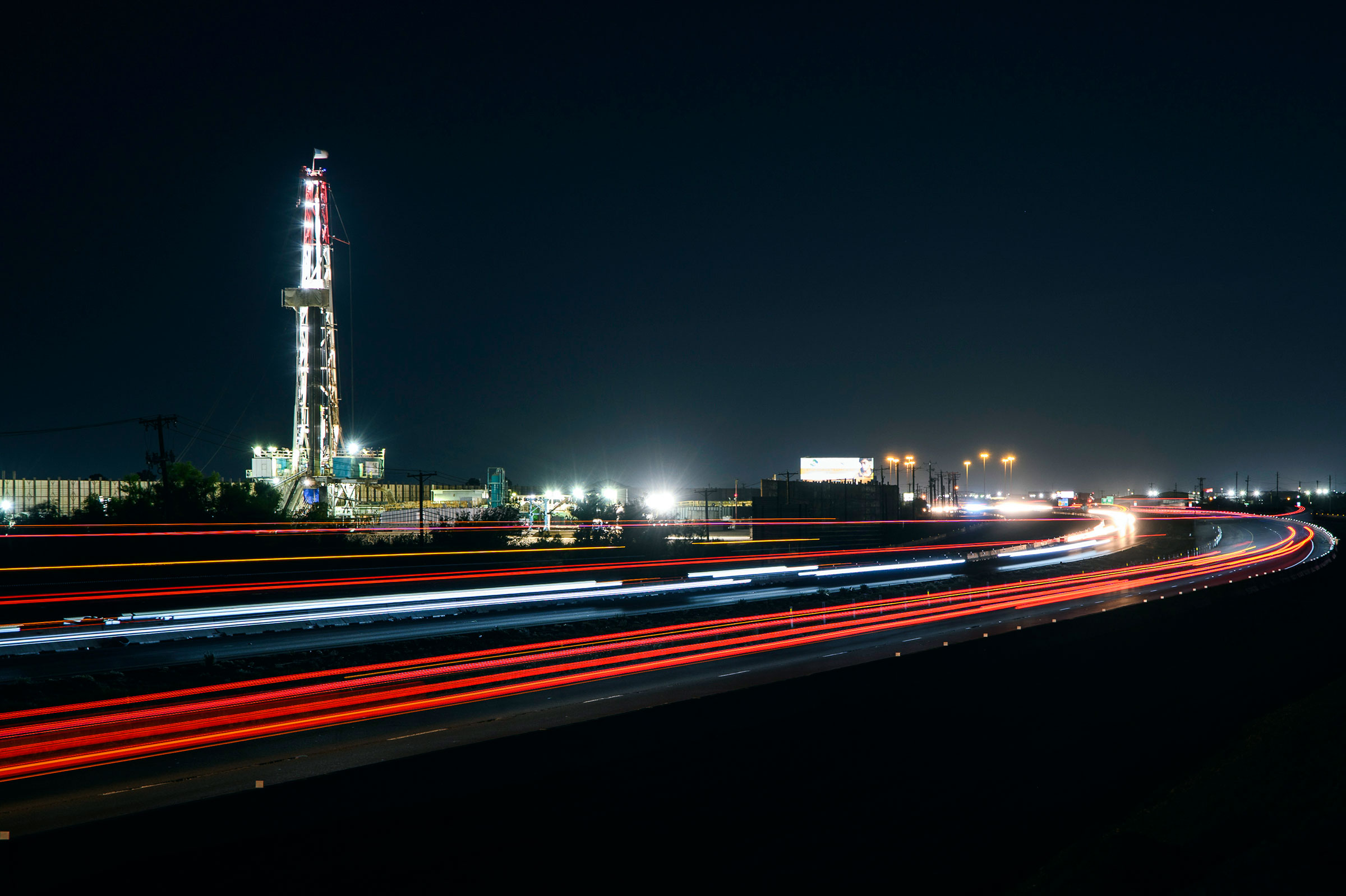 Motorists drive past an oil rig alongside Interstate 20 in Midland, Texas on July 7, 2022. (Eli Hartman—Odessa American/AP)