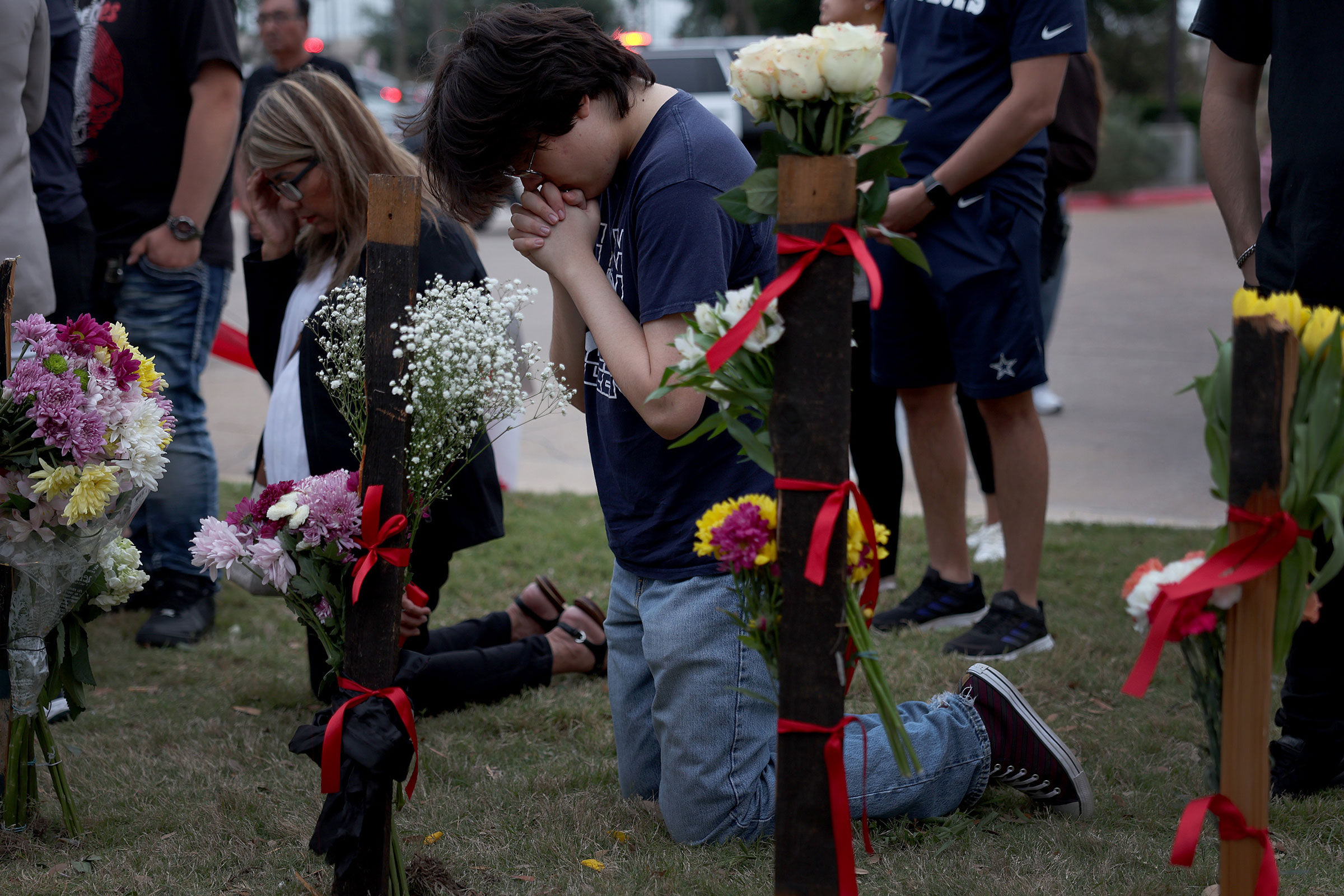 People pray at a memorial next to the Allen Premium Outlets in Allen, Texas, on May 7, 2023. (Joe Raedle—Getty Images)