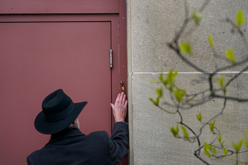 Rabbi Jeffrey Myers touches the last remaining mezuzah of the Tree of Life Congregation building at the conclusion of a ceremony to say the l'hitraot, or “until we see each other again,” to the building ahead of planned construction on April 23, 2023, in Pittsburgh, PA. Jury selection started on Monday, April 24, for the upcoming trial of Robert Bowers, the gunman who massacred 11 Jewish congregants at the Tree of Life Synagogue in 2018. (Jahi Chikwendiu—The Washington Post/ Getty Images)