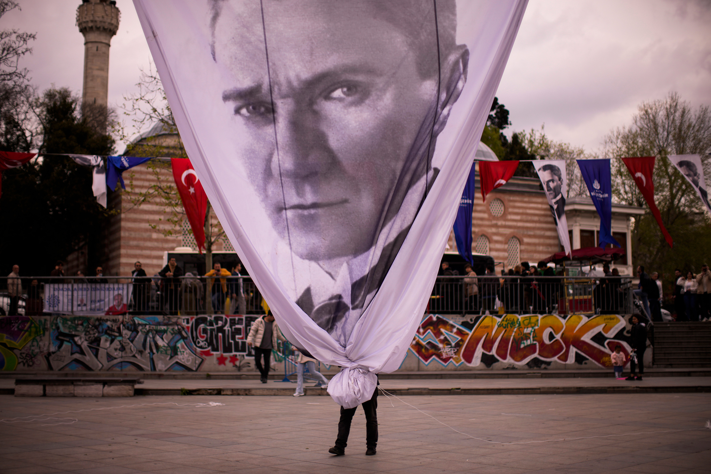 A worker removes a giant banner with the image of Mustafa Kemal Atatürk, founder of modern Turkey, at the end of a rally by Istanbul Mayor and main opposition CHP party member Ekrem Imamoglu, in Istanbul on April 26. (Francisco Seco—AP)