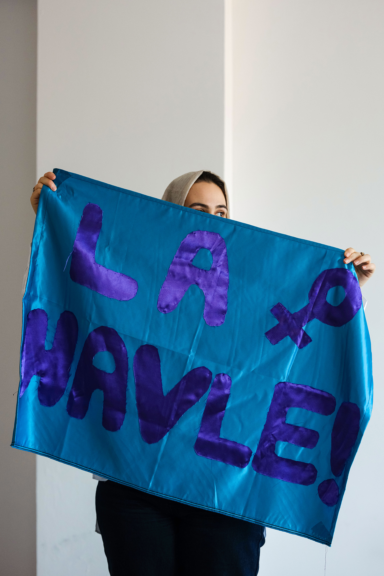 Zeynep, a 28-year-old LGBTQ+ member of the Havle group, holding a Havle sign.