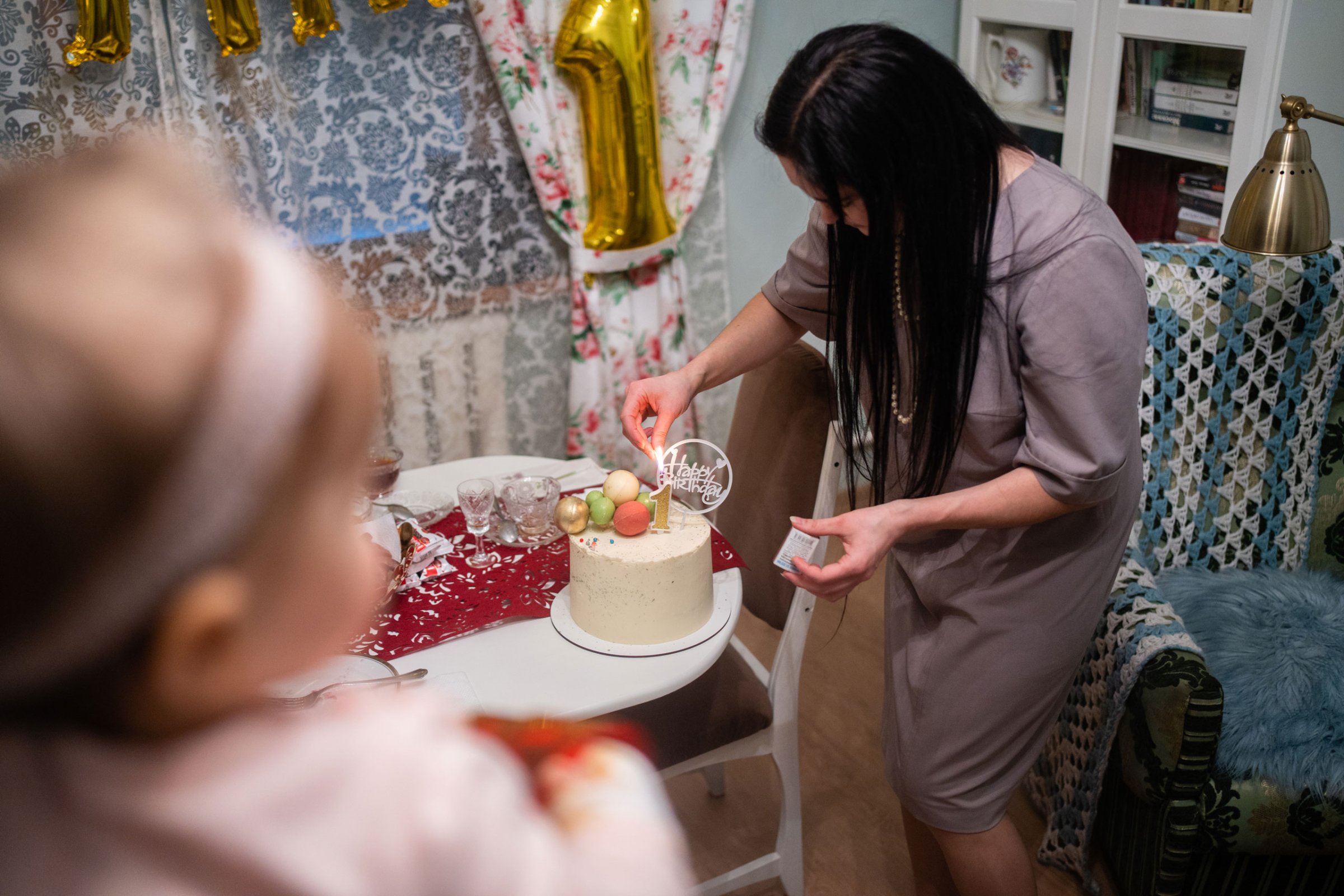 Nina lights a candle for her daughter Yulia’s 1st birthday cake