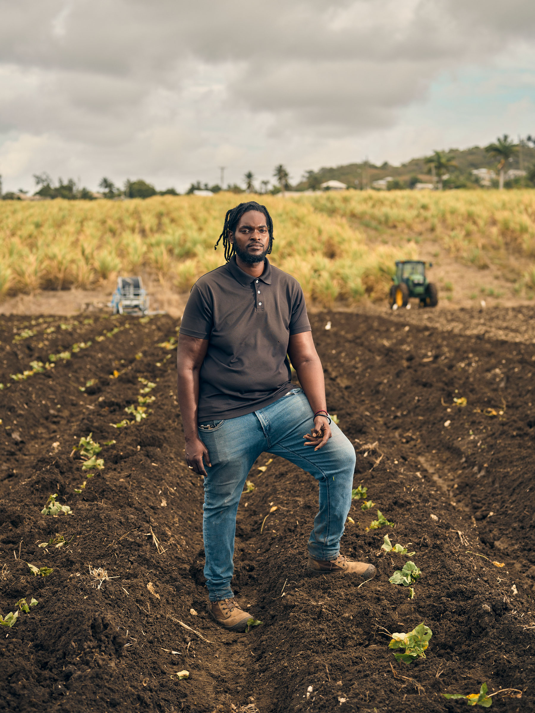 Farm manager standing between a row of crops in Barbados