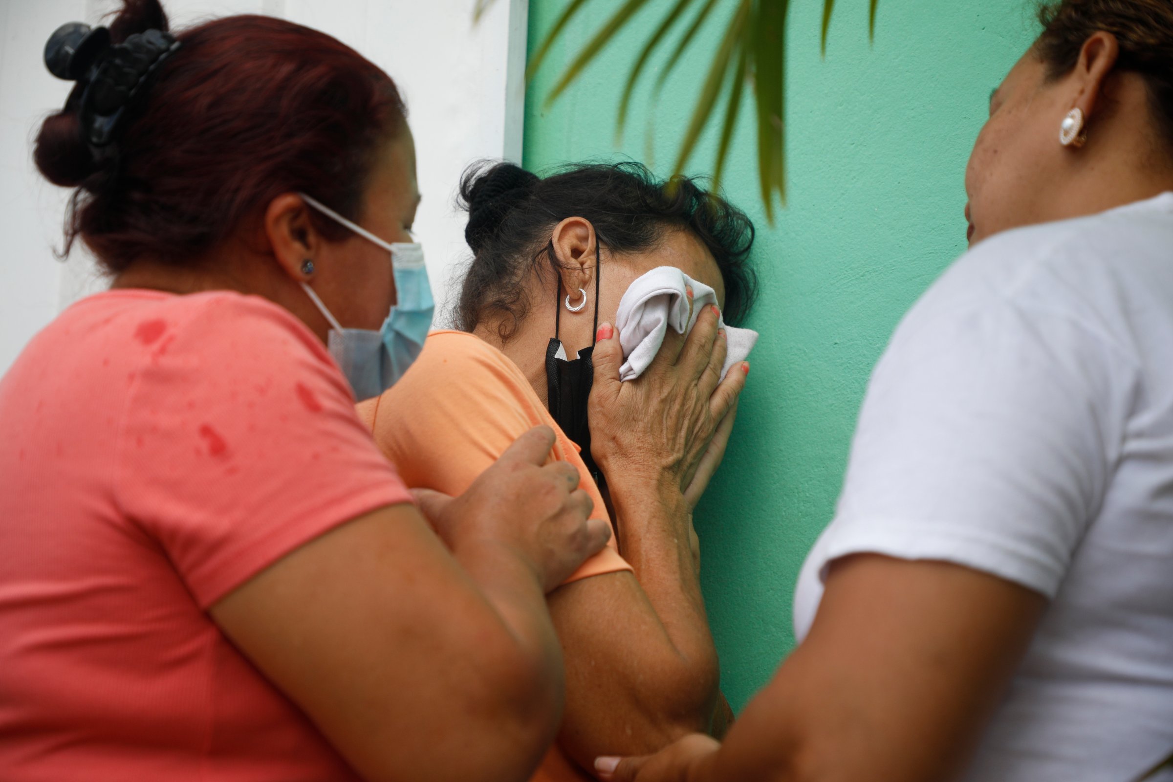 Relatives of inmates wait in distress outside the entrance to the women's prison in Honduras
