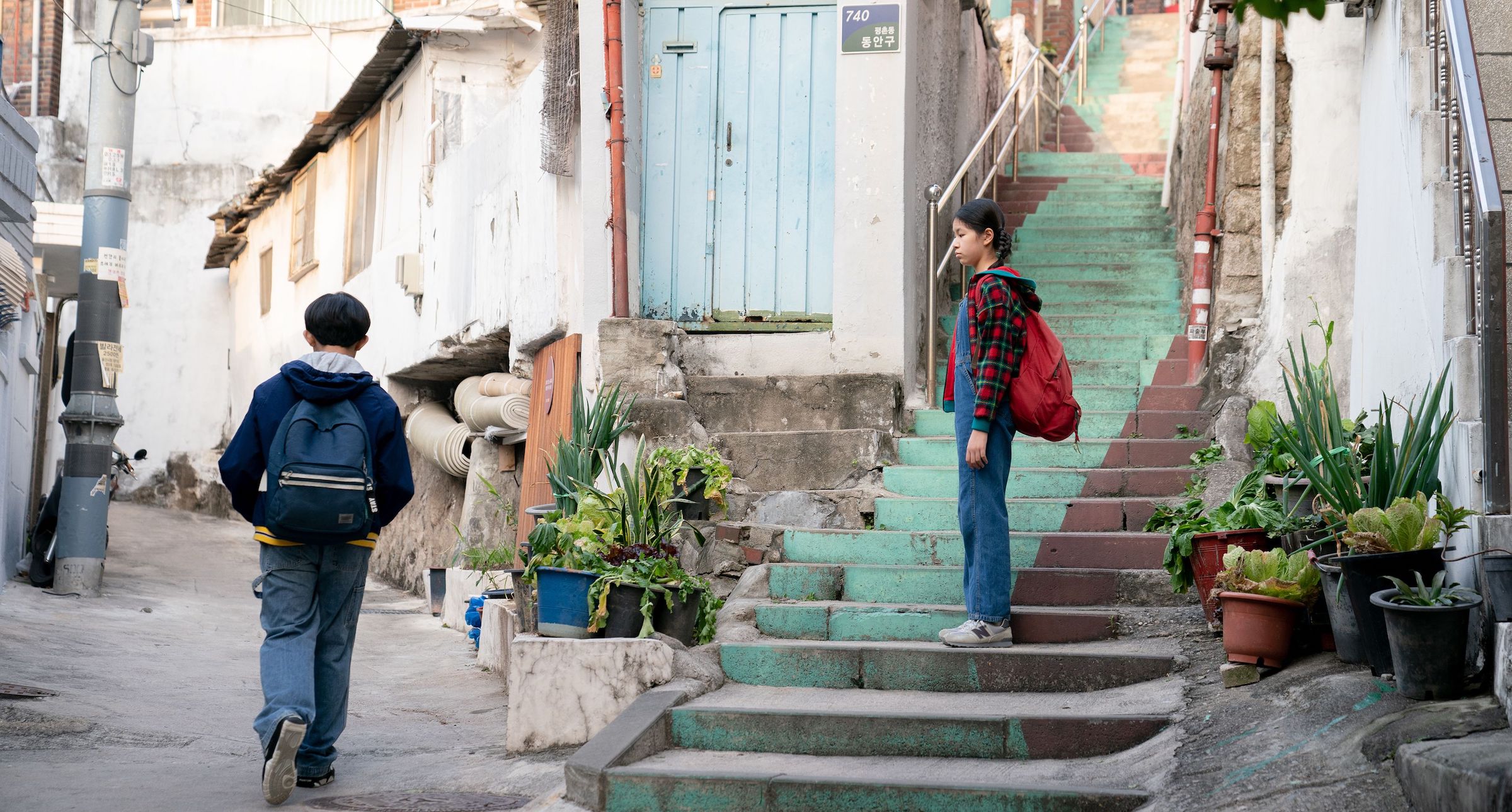 Young Hae Sung (Leem Seung-min) and young Nora (Moon Seung-ah) part ways on the walk home from school in Seoul. (Courtesy of A24)