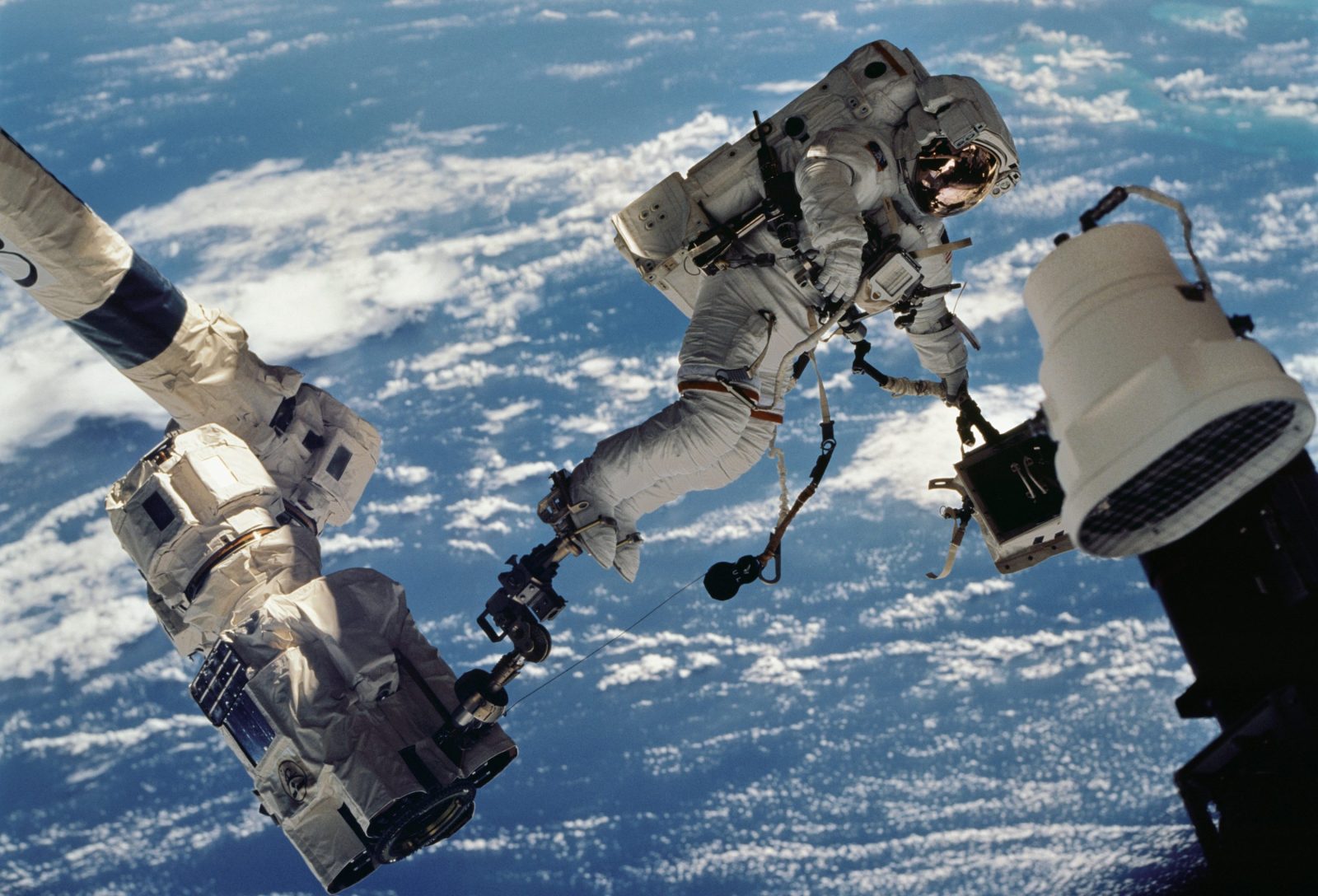 ASTRONAUT WOLF, DAVID-A. STS-112 MISSION SPECIALIST, ANCHORED TO A FOOT RESTRAINT ON SPACE STATION REMOTE MANIPULATOR SYSTEM (SSRMS) OR CANADARM2, CARRIES THE STARBOARD ONE OUTBOARD NADIR EXTERNAL CAMERA.