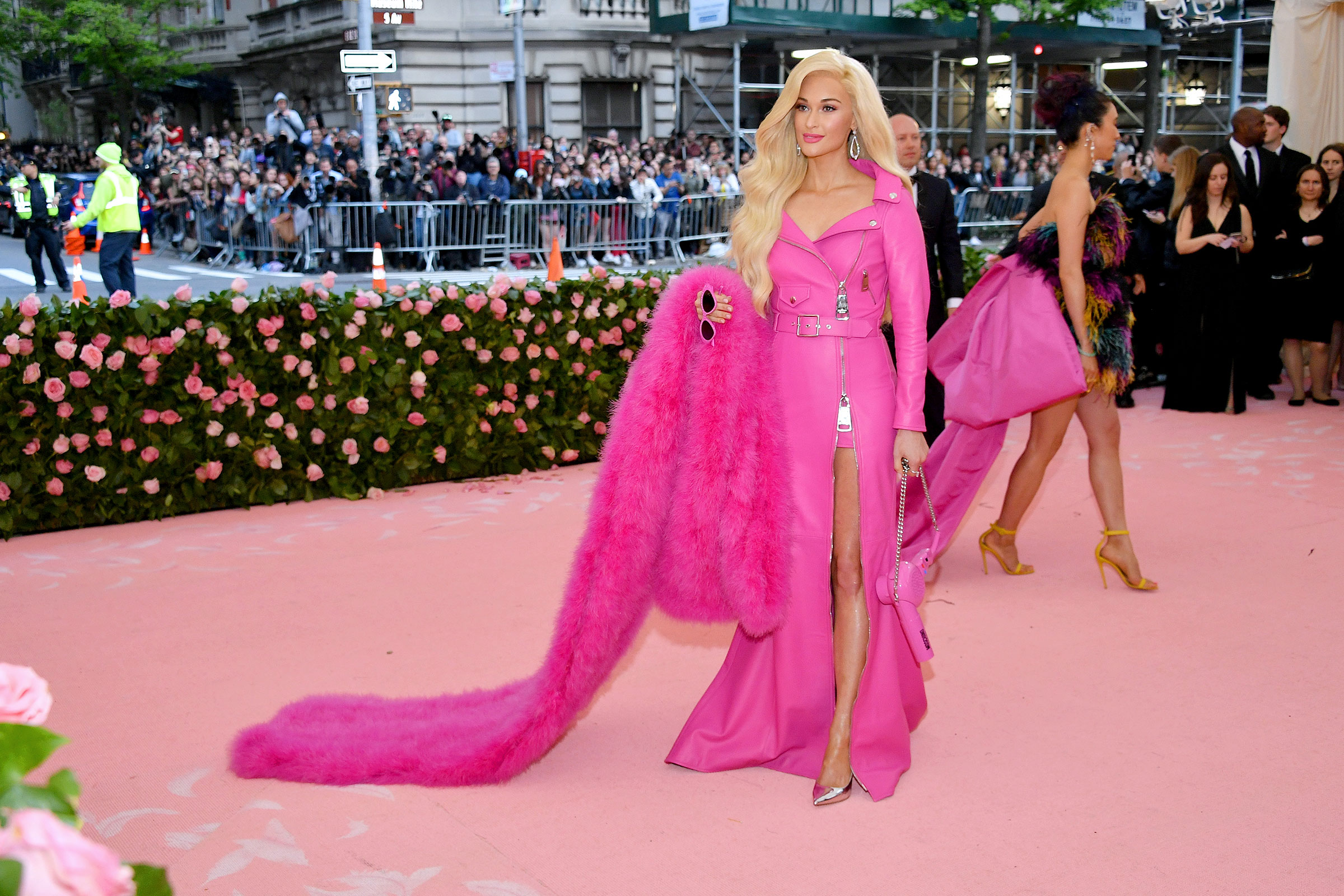 Singer Kacey Musgraves stands on the met gala carpet getting her photo taken wearing a full hot pink outfit that makes her look like a barbie doll