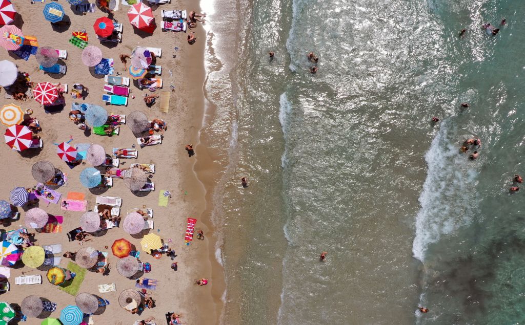 An aerial view of sunbathers under colorful parasols in Aydin, Turkey on July 23, 2019.
