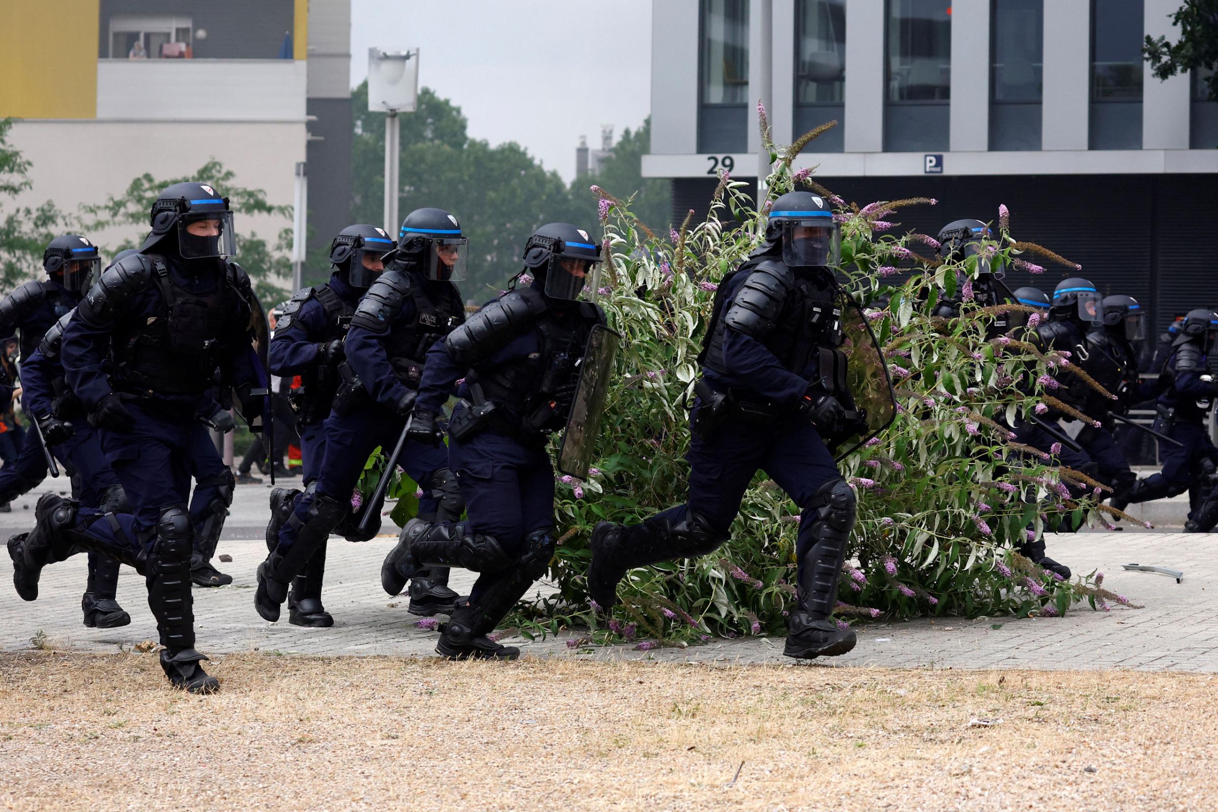 French riot police run amid clashes with protesters during a march in tribute to Nahel