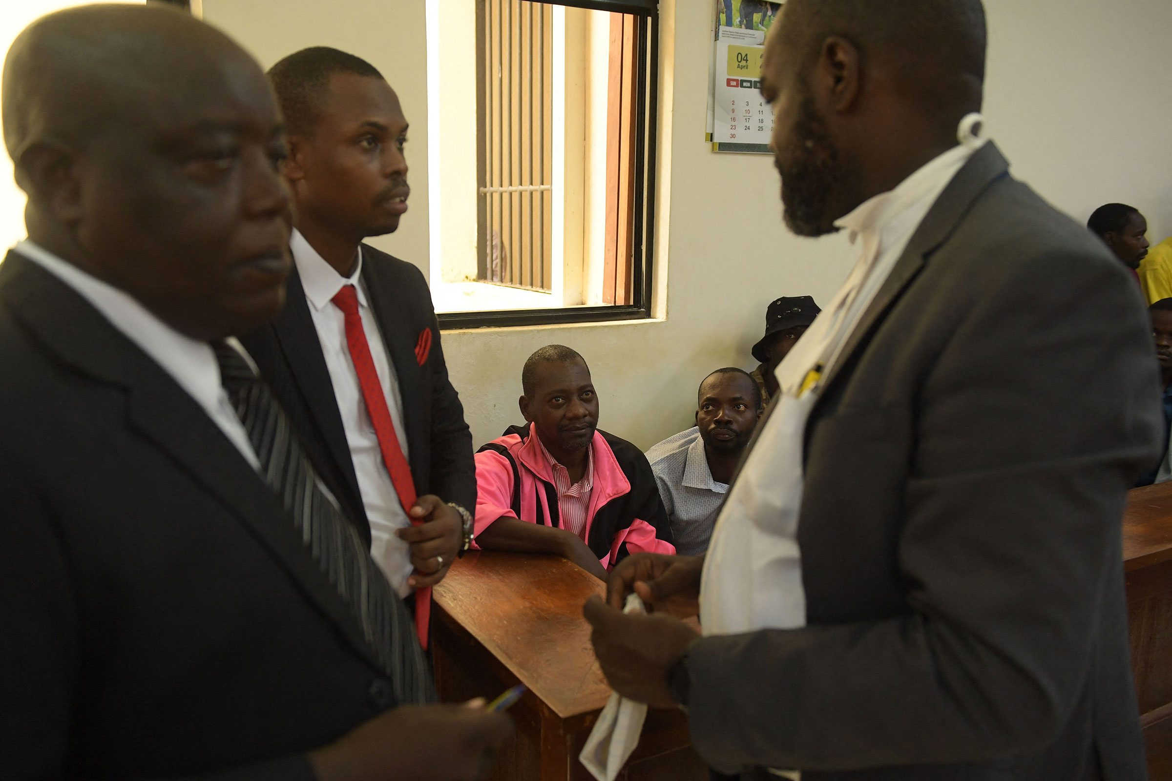 Paul Nthenge Mackenzie looks at his lawyer as he appears in a court