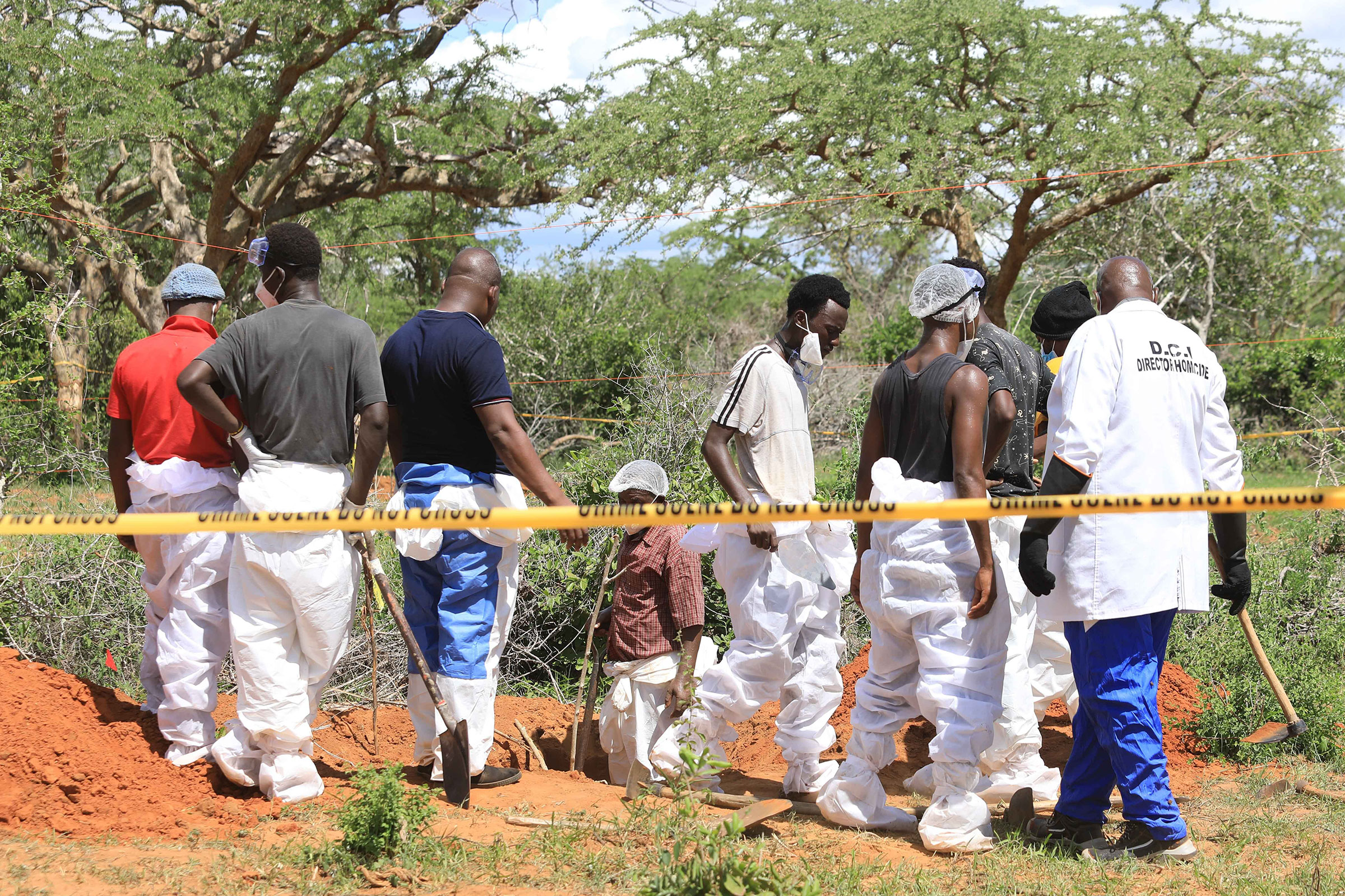 Officials inspect a forest where bodies were found near the Good News International Church