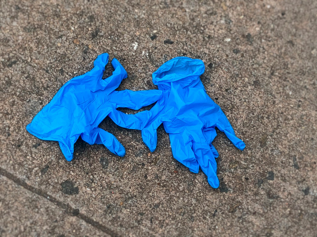 Medical gloves discarded on sidewalk.