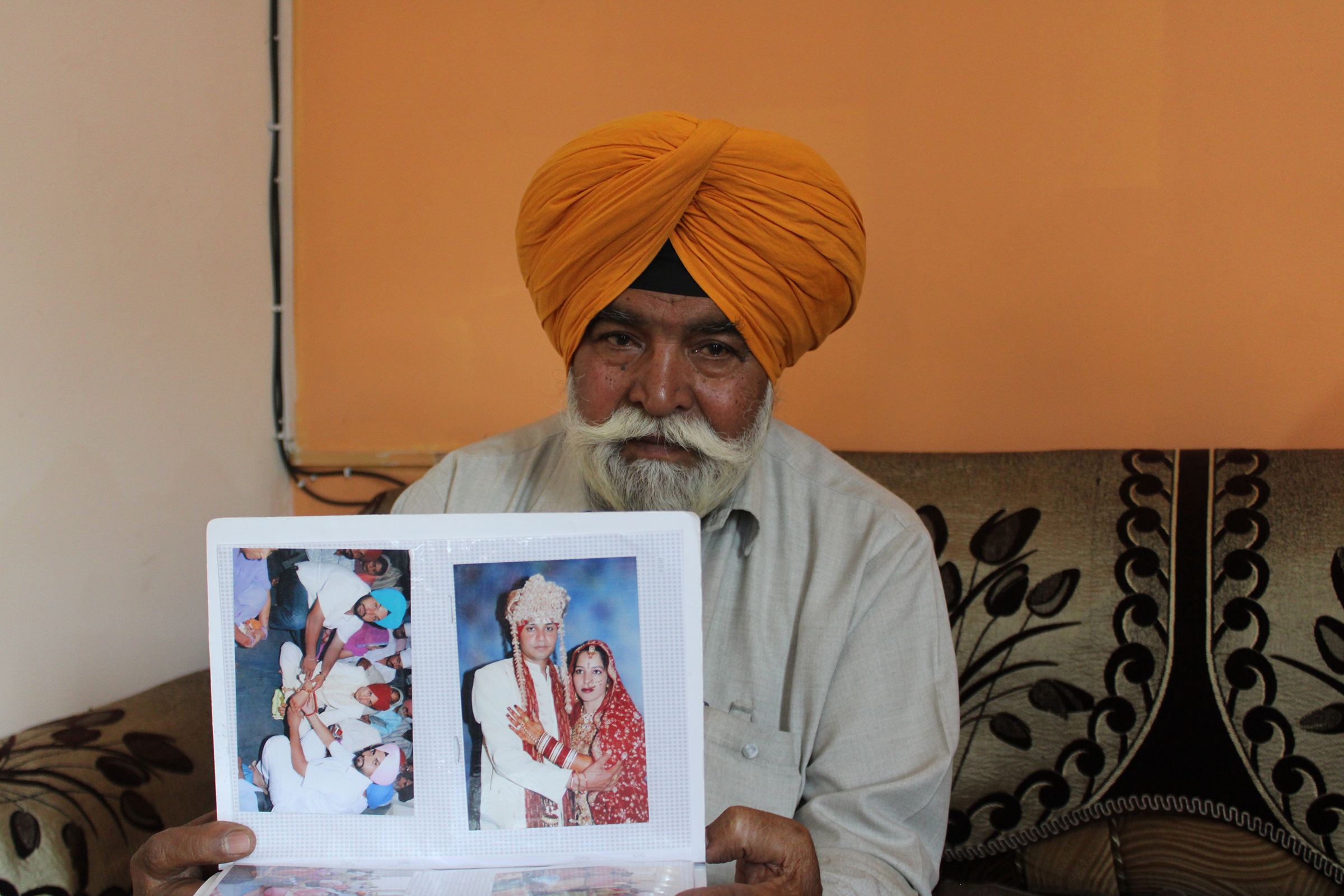 Jit Singh showing his daughter Jagdeep Kaur’s wedding album at his home in Akalgarh, Ludhiana, on April 9. (Bilal Kuchay)