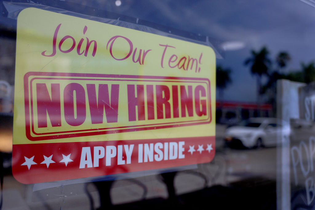 A 'Now Hiring' sign posted in the window of a restaurant looking to hire workers on May 05, 2023 in Miami, Florida. (Joe Raedle / Getty Images)