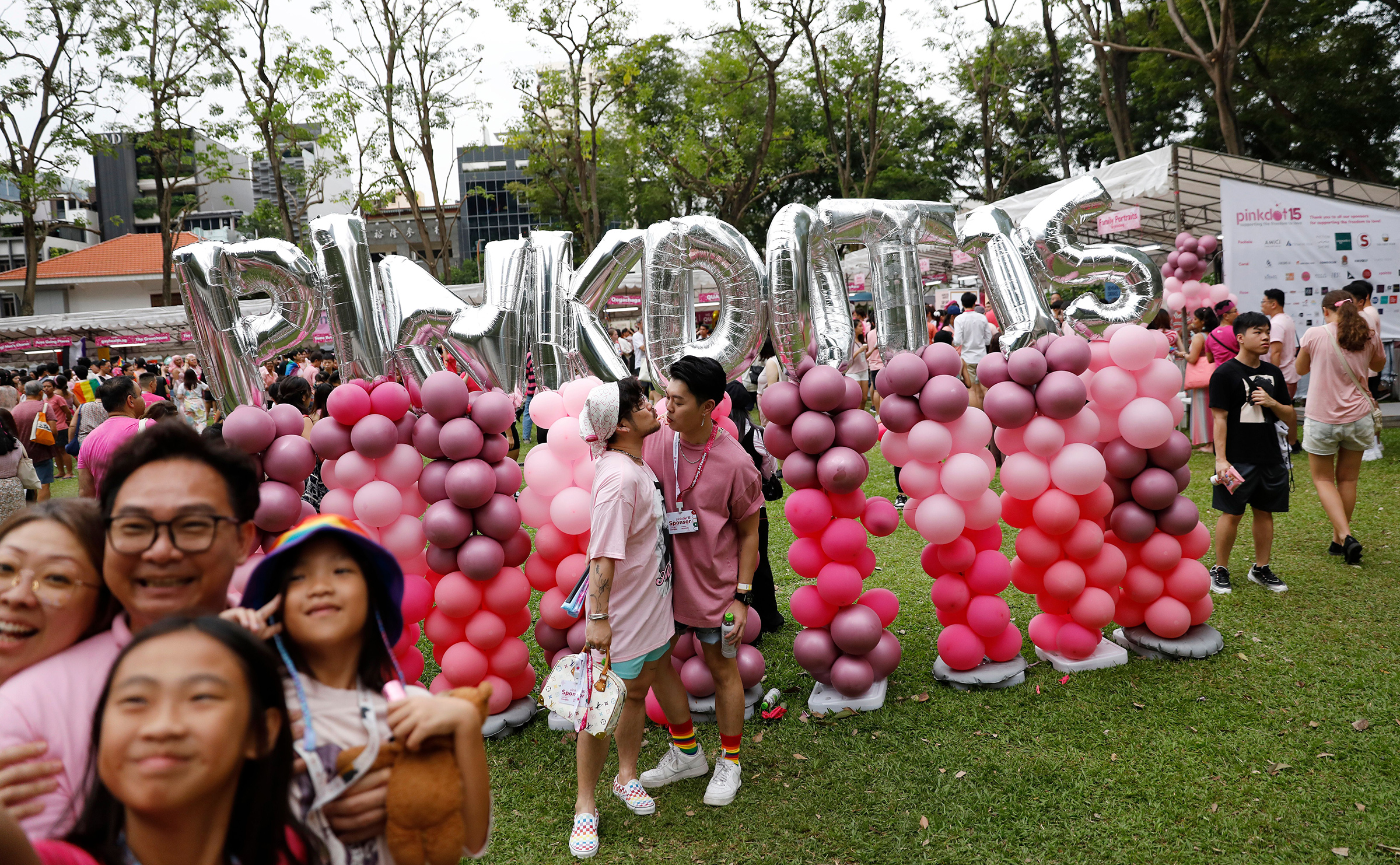 Pink Dot attendees pose for photos near balloons at Hong Lim Park in Singapore on June 24, 2023.