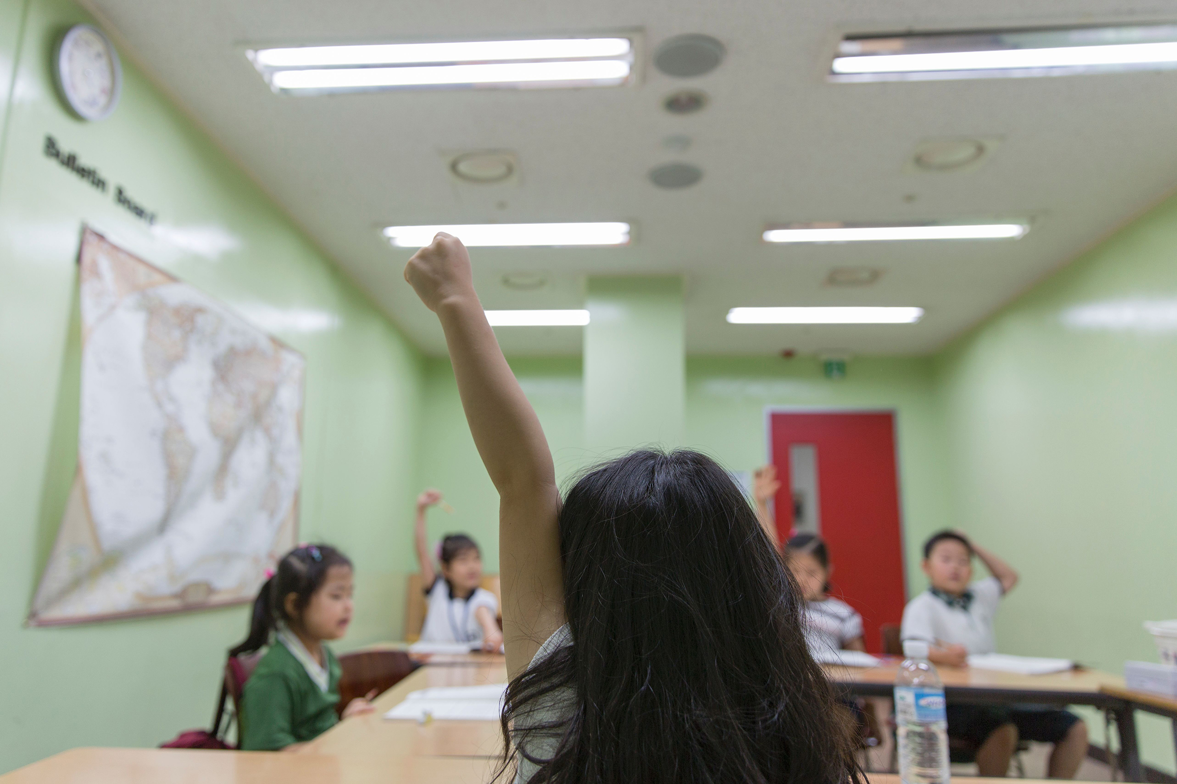A pupil raises her hand during class at the Jongno Hagwon Academy in Seoul on Aug. 10, 2016. (Yelim Lee—AFP/Getty Images)