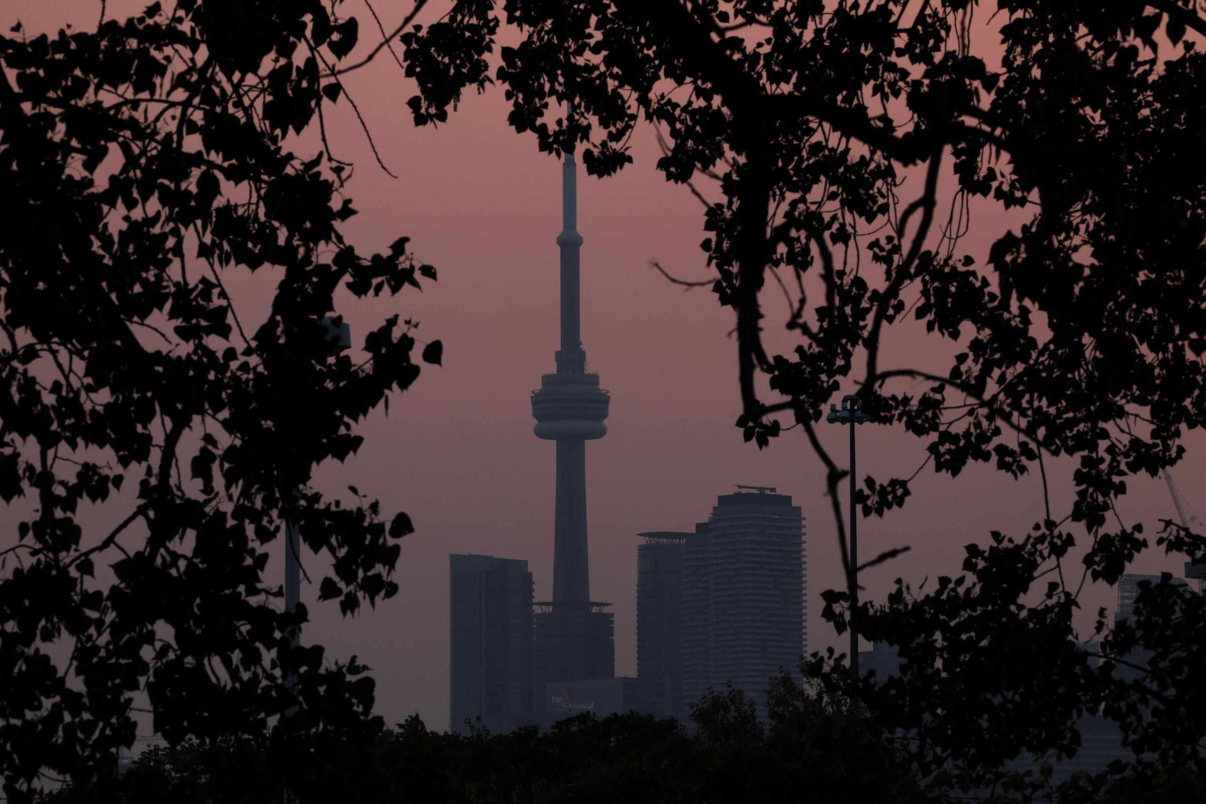 Smoke from forest fires in Northern Ontario and in Quebec contribute to pink hazy sunset in the city from the Cherry Beach in Toronto