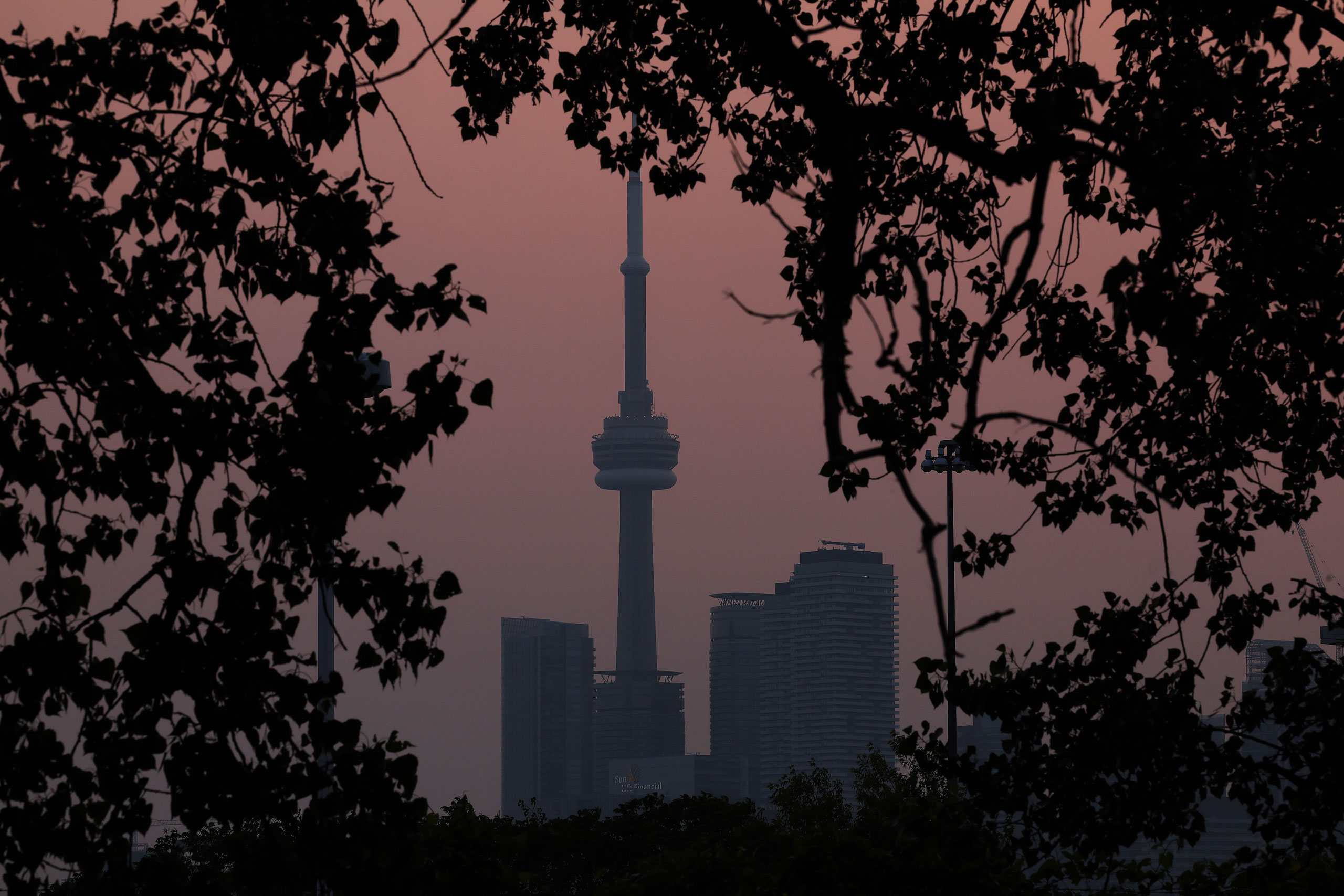Smoke from forest fires in Northern Ontario and in Quebec contribute to pink hazy sunset in the city from the Cherry Beach over Toronto, on June 6, 2023. (Steve Russell—Toronto Star/Getty Images)
